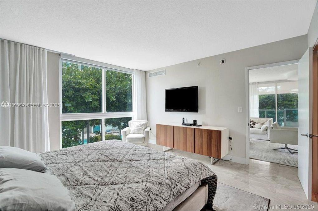 Floor-to-ceiling windows, polished stone flooring, and neutral wall tones