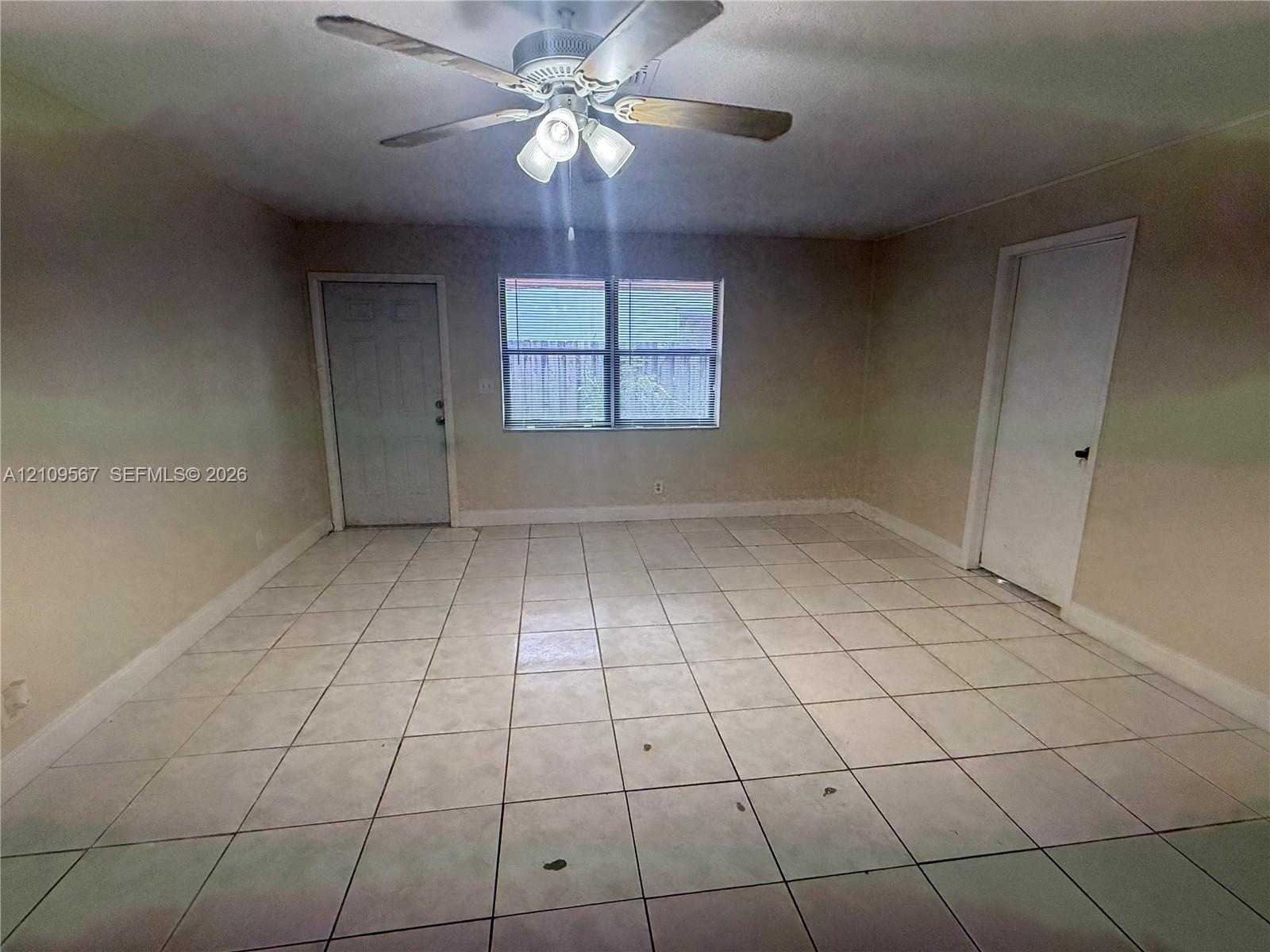 Ceramic tile flooring, neutral wall tones, multi-pane window, and a central ceiling fan with integrated lighting Ceramic tile flooring, neutral wall tones, multi-pane window, and a central ceiling fan with integrated lighting