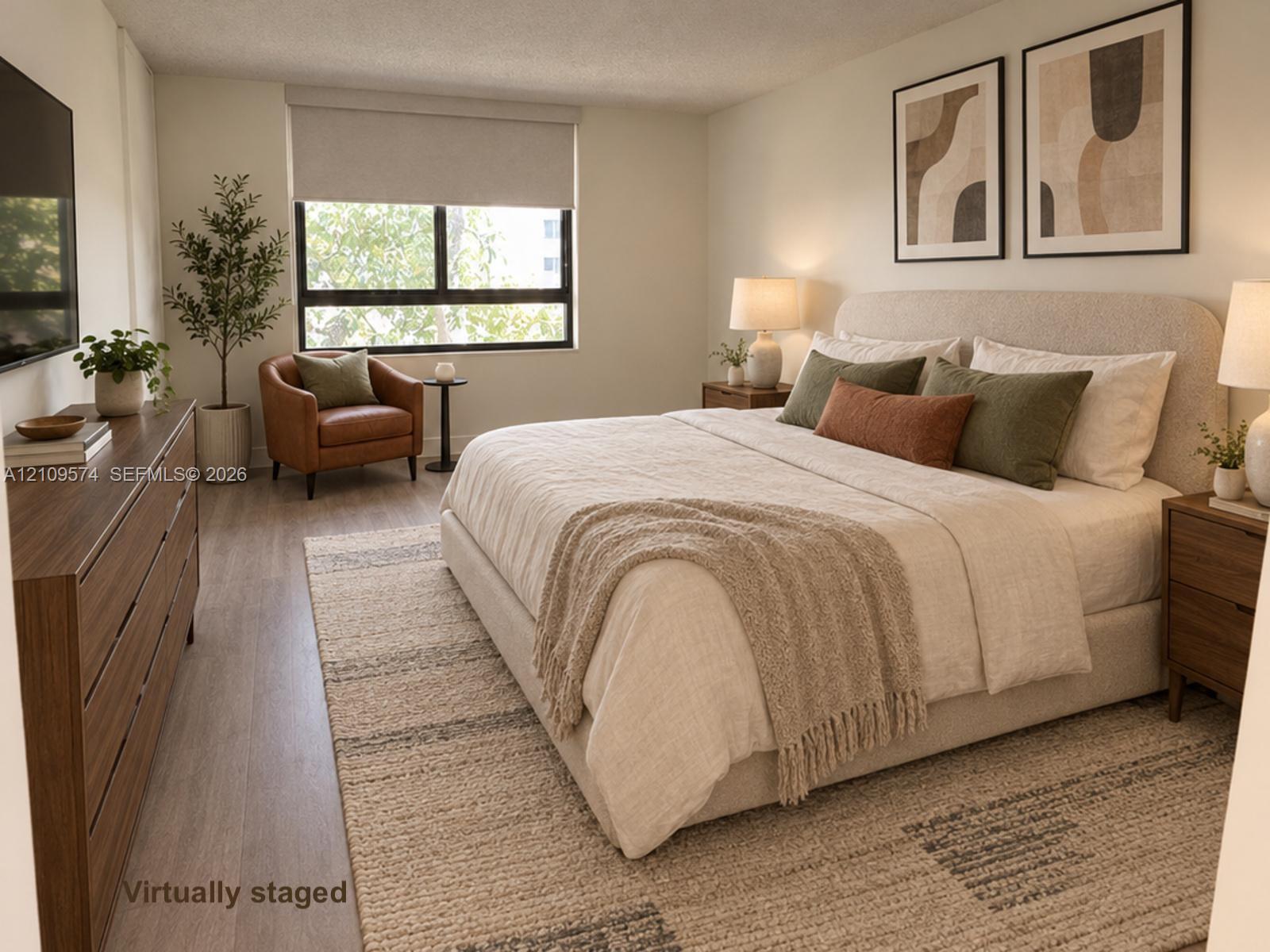 Staged. Neutral wall palette featuring vinyl wood-finish flooring and a large picture window with a retractable roller shade Staged. Neutral wall palette featuring vinyl wood-finish flooring and a large picture window with a retractable roller shade