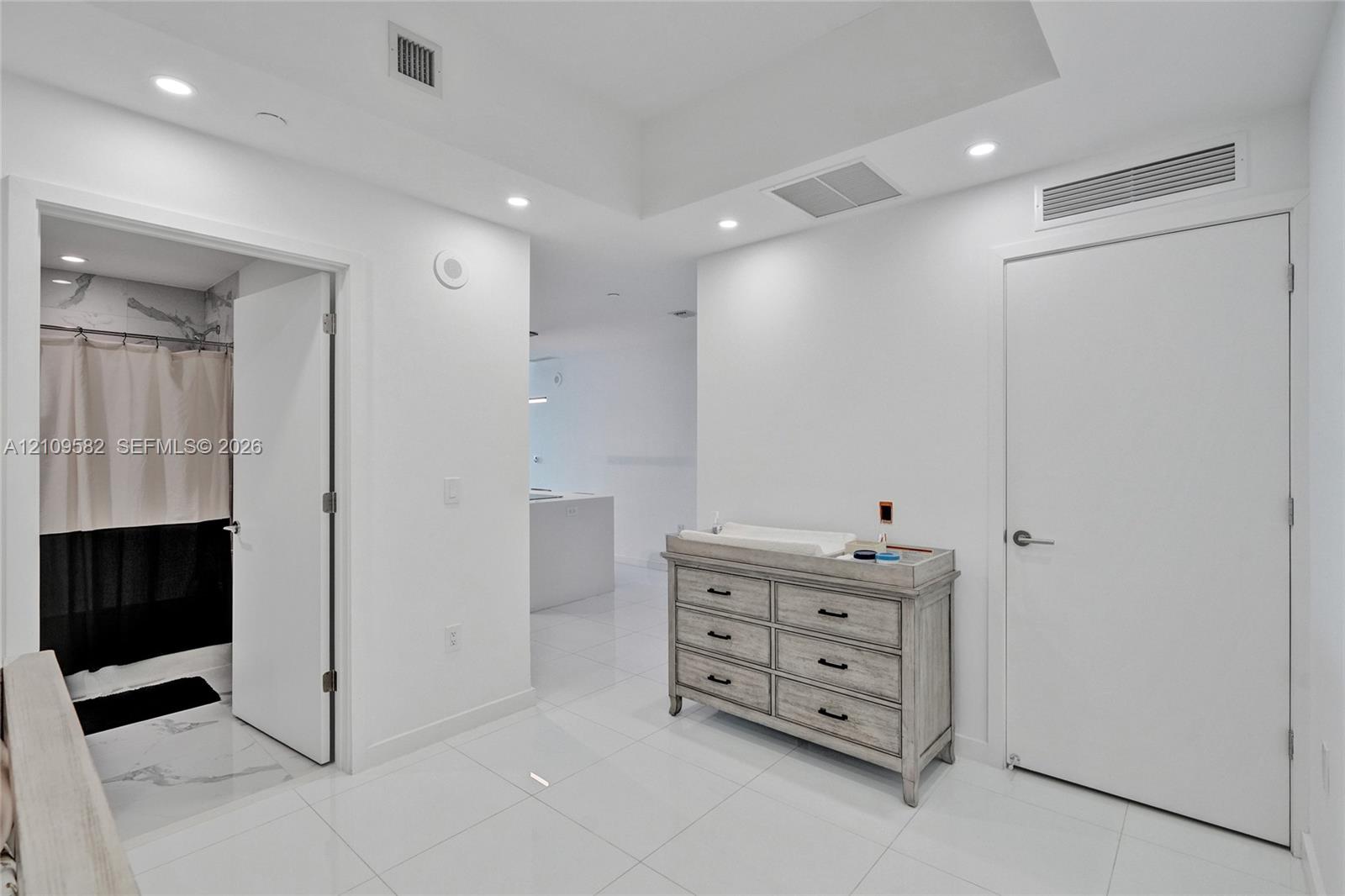 Polished tile flooring, recessed ceiling lighting, and solid-core interior doors