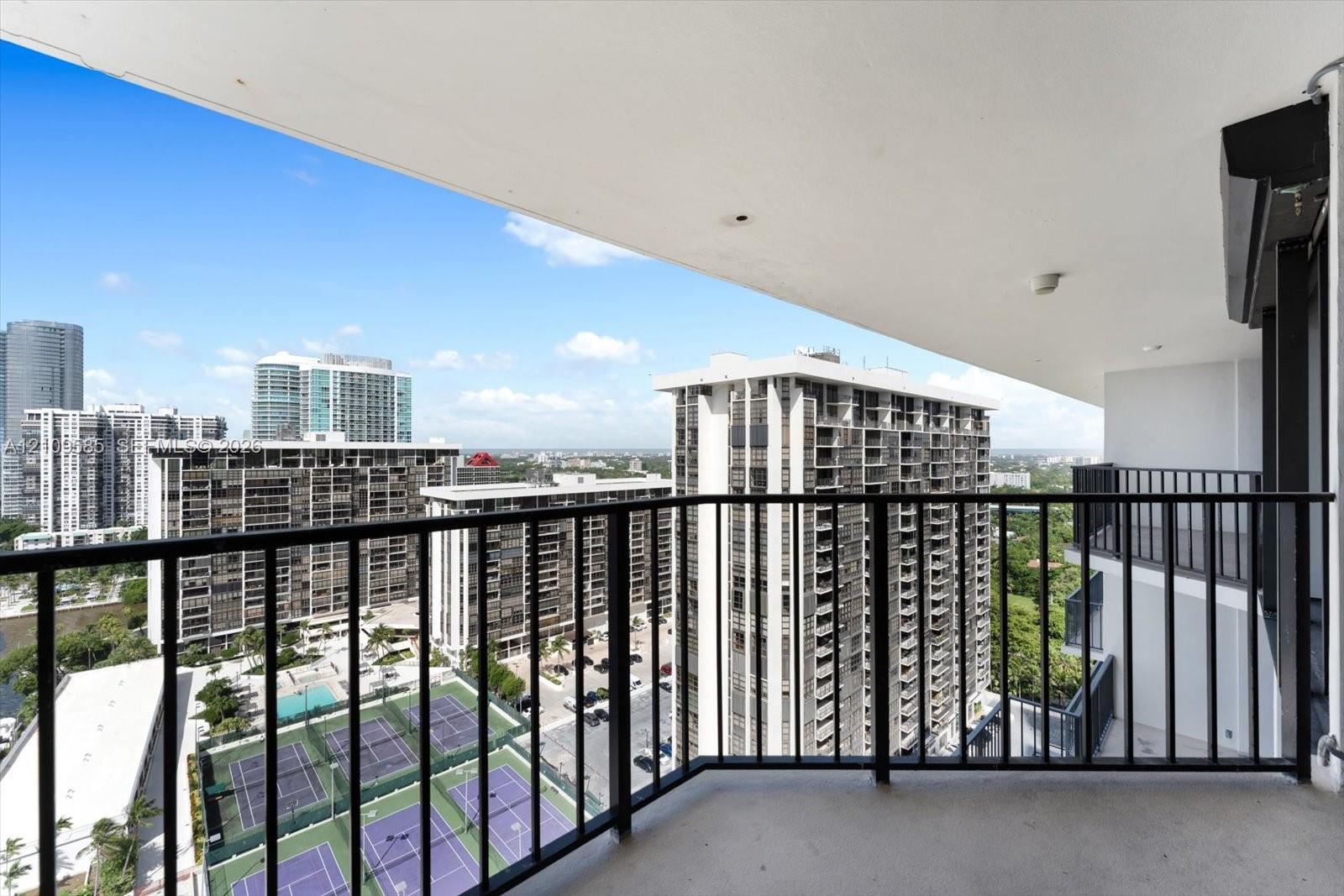Covered balcony featuring black metal railings and overhead lighting