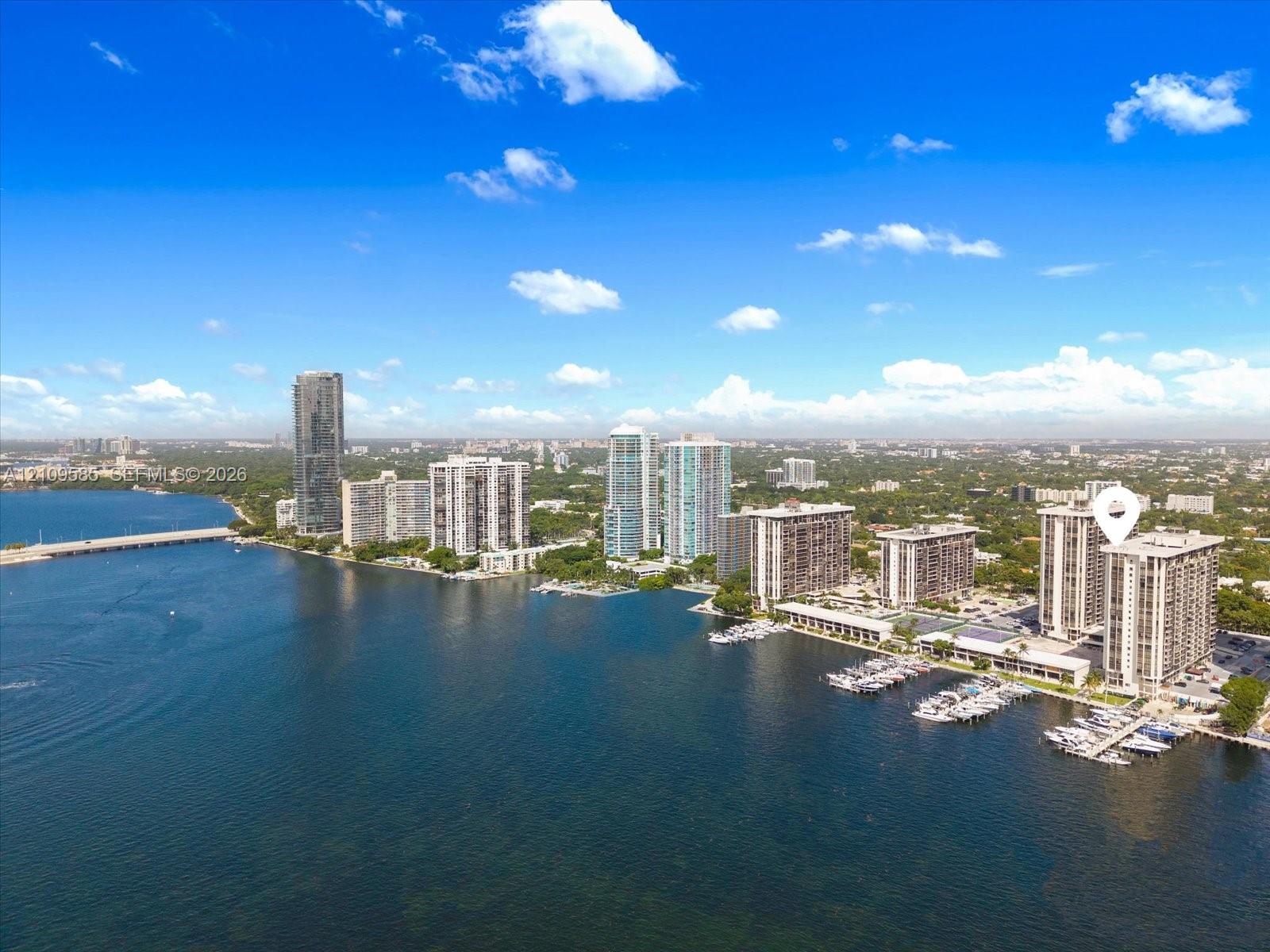 Waterfront high-rise building featuring boat slips, an outdoor swimming pool, and proximity to expansive coastal waterways