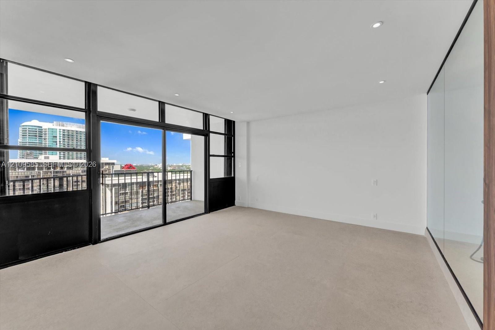 Primary view Floor-to-ceiling windows, sliding glass door access to a private balcony, recessed lighting, and neutral carpeting