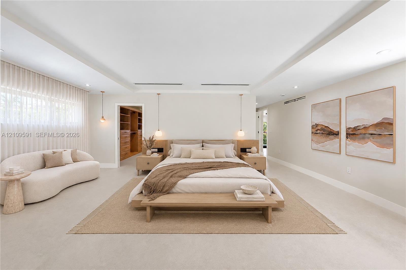 Virtually Staged: Spacious room featuring a recessed tray ceiling, neutral wall-to-wall flooring, built-in wooden headboard with integrated side tables, pendant lighting, and a walk-in closet with custom wooden shelving