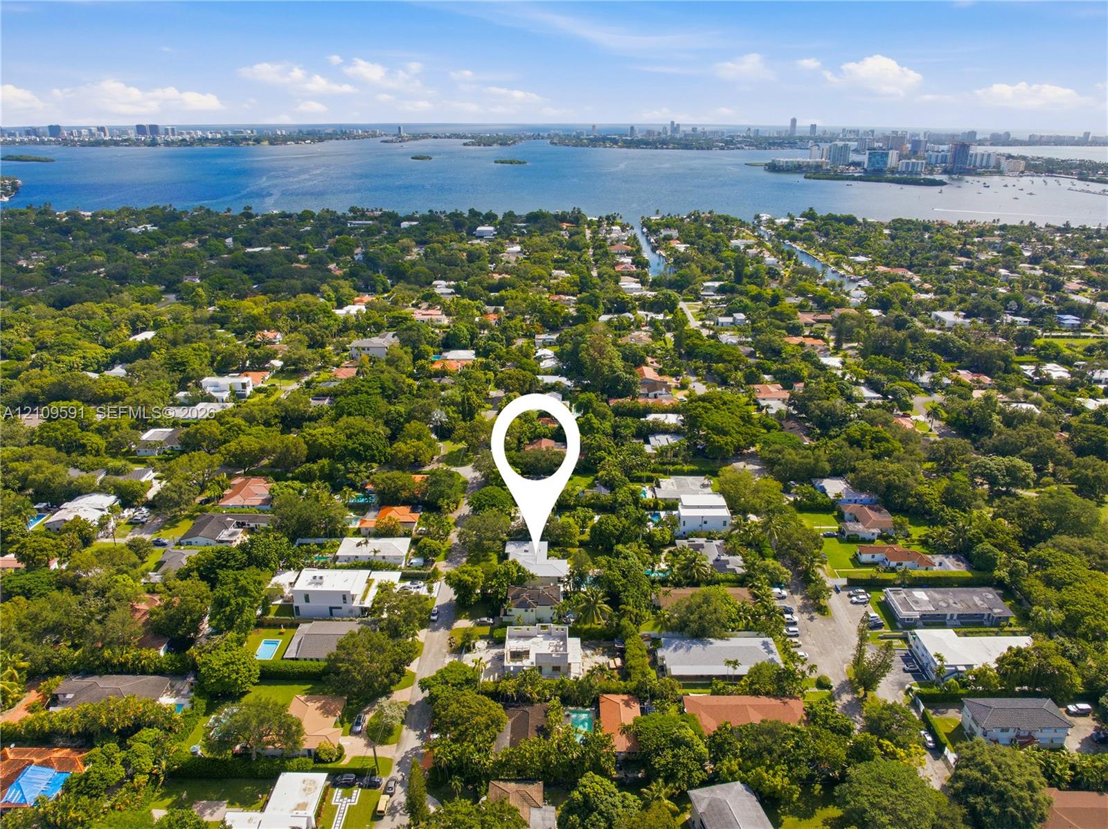 Aerial perspective of a property featuring mature landscape, extensive tree canopy coverage, and proximity to the coastal bay