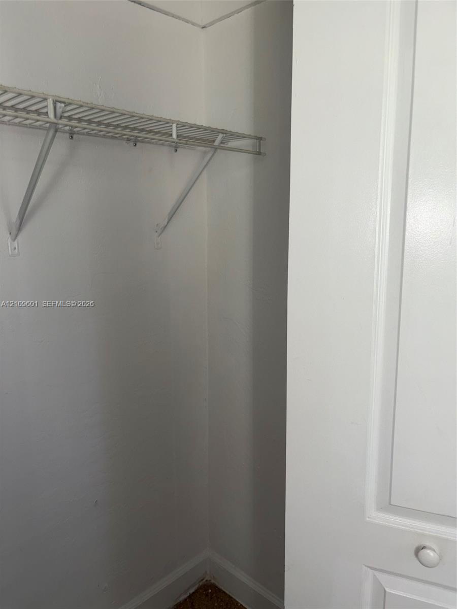 2nd' bedroom closet featuring a white-painted door with a round knob and a built-in wire storage shelf