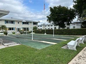 Outdoor shuffleboard courts featuring a paved surface, permanent net stanchions, and surrounding concrete benches