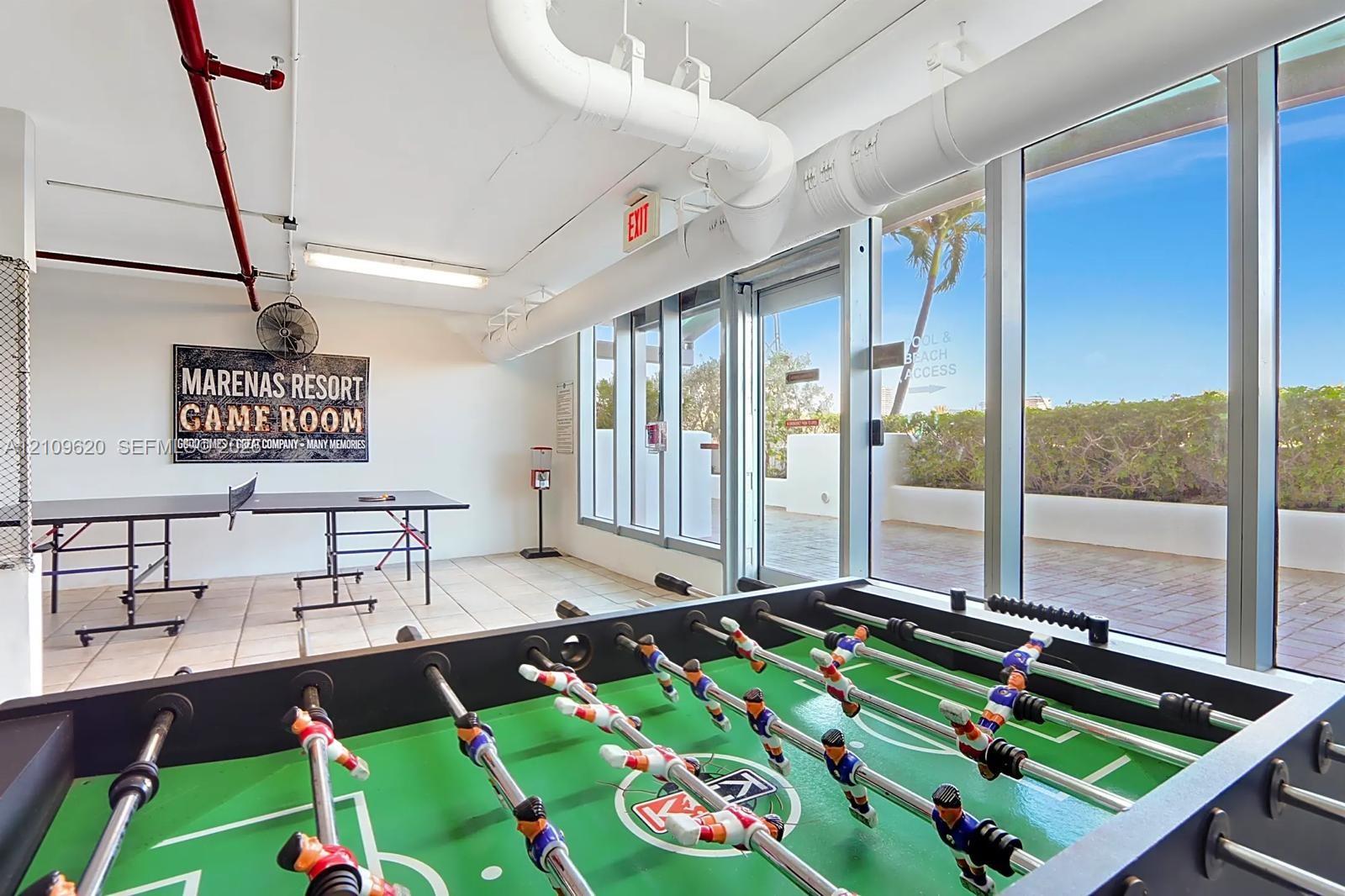 Recreational space featuring large-format ceramic floor tiles, expansive floor-to-ceiling glass windows, and direct exterior terrace access