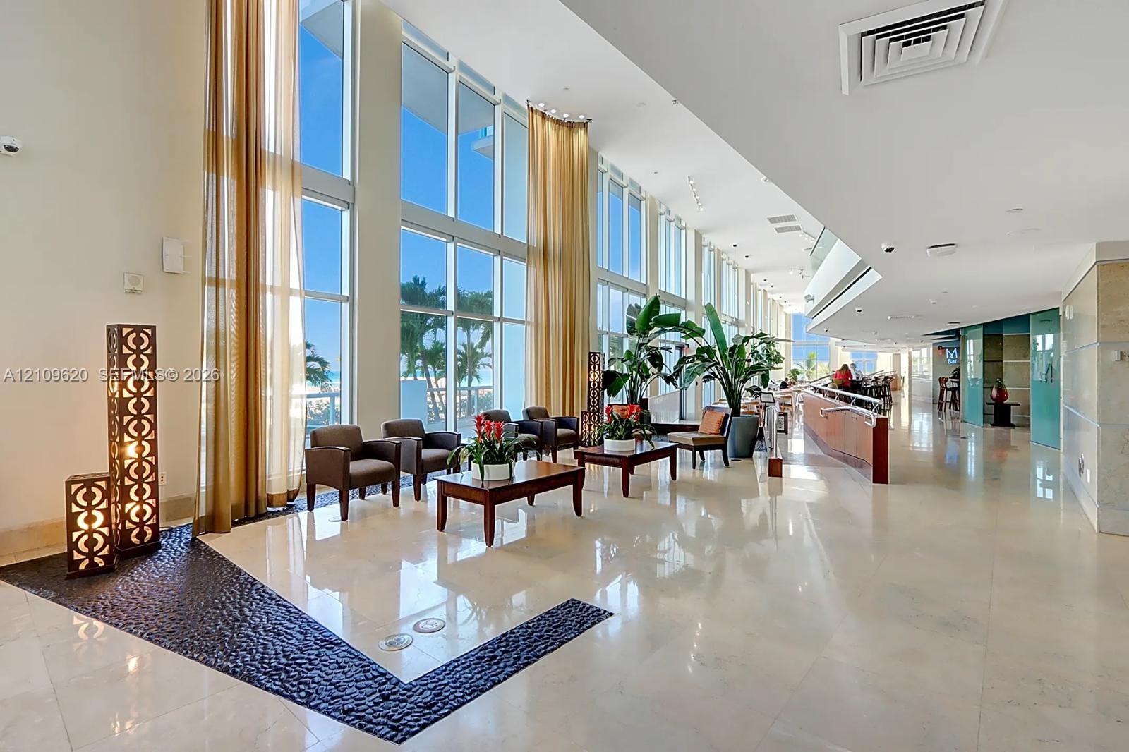 Floor-to-ceiling windows, polished stone flooring, recessed ceiling lighting, and decorative stone accent flooring inlay