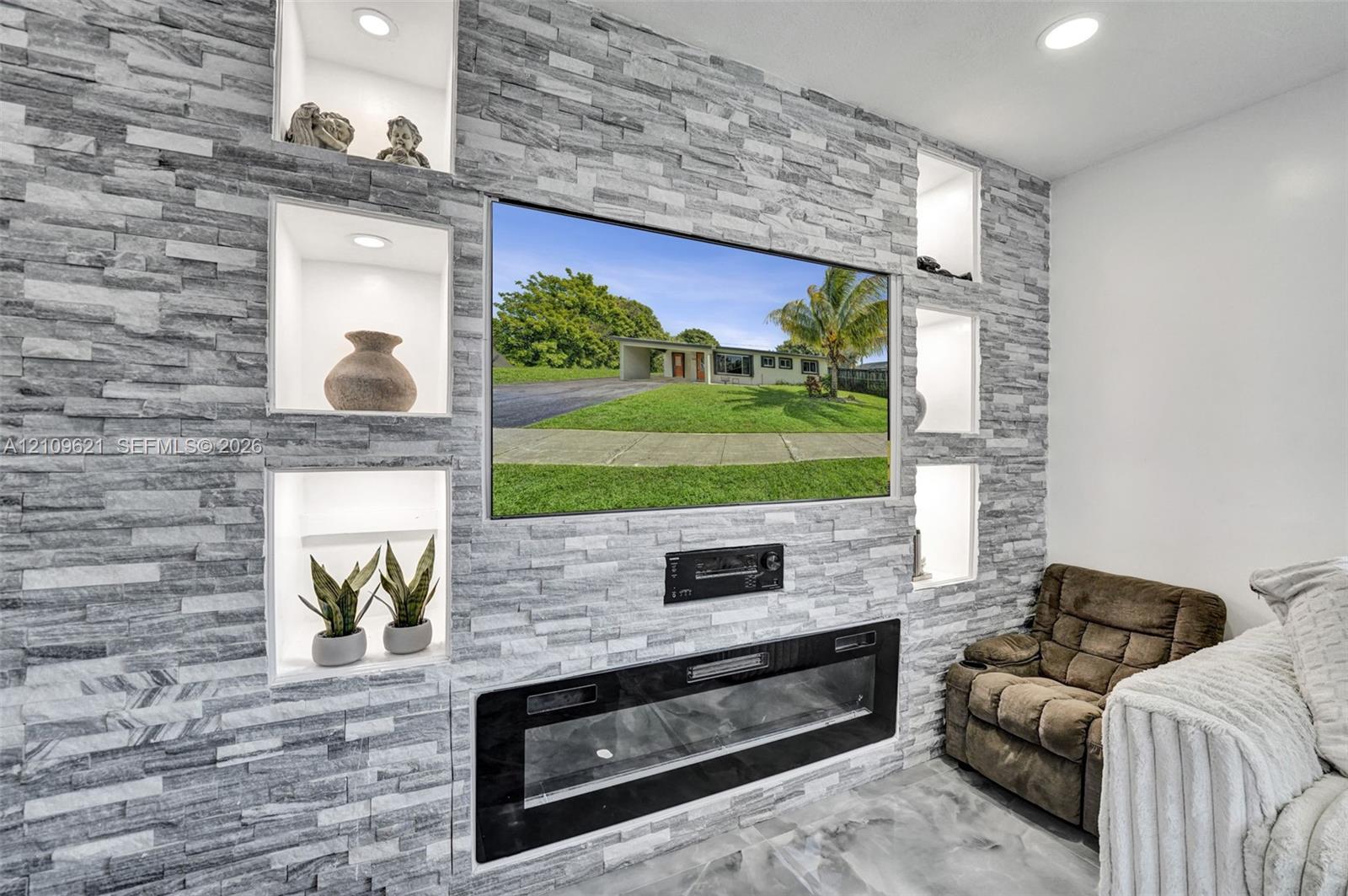 Floor-to-ceiling stone-veneer accent wall featuring five recessed display niches with integrated lighting and a built-in electric fireplace