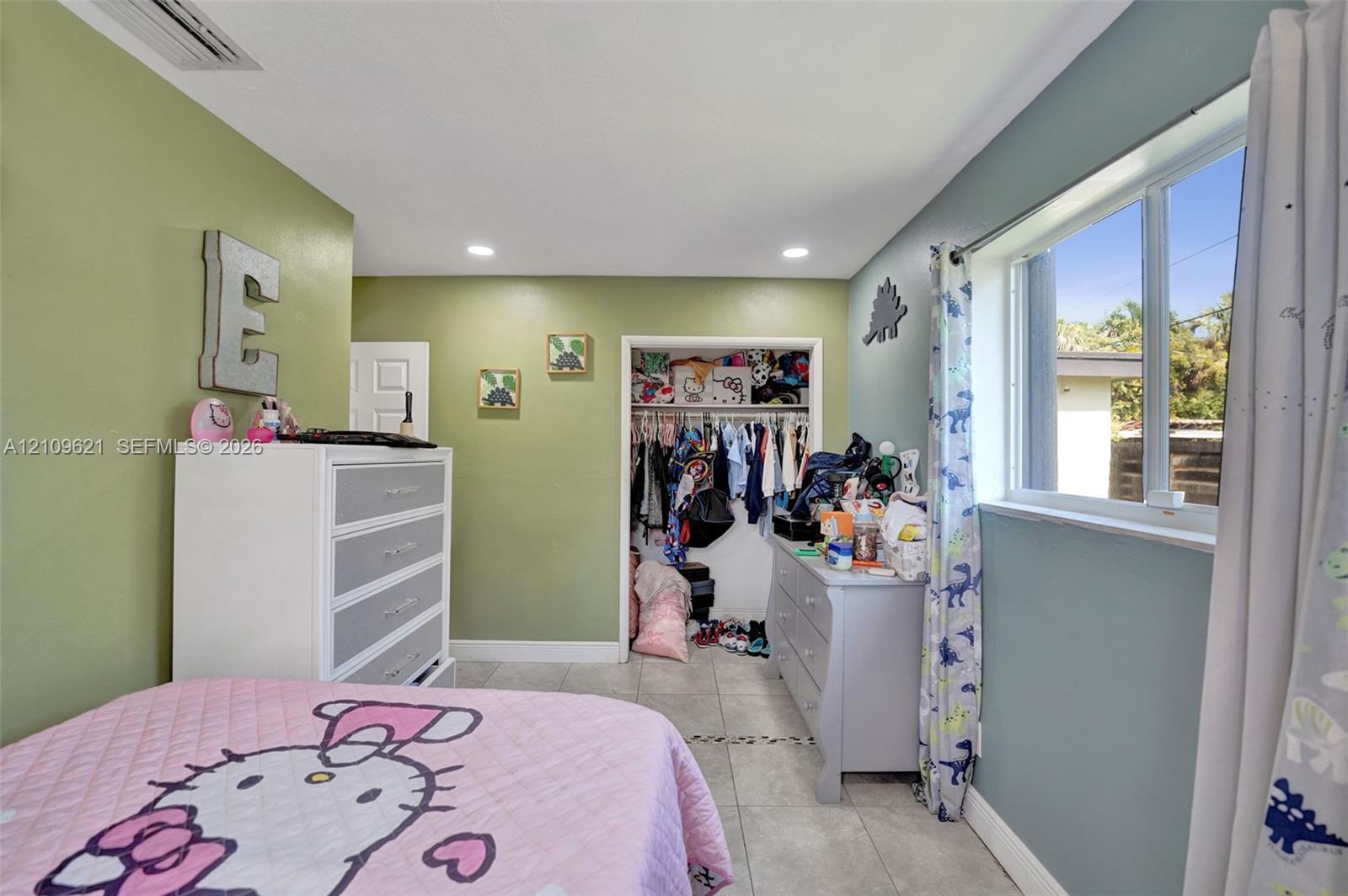 Interior room featuring tile flooring, recessed ceiling lighting, and a reach-in closet
