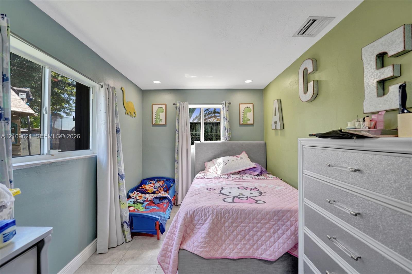 Neutral-toned tiled flooring, recessed ceiling lighting, and dual-pane windows