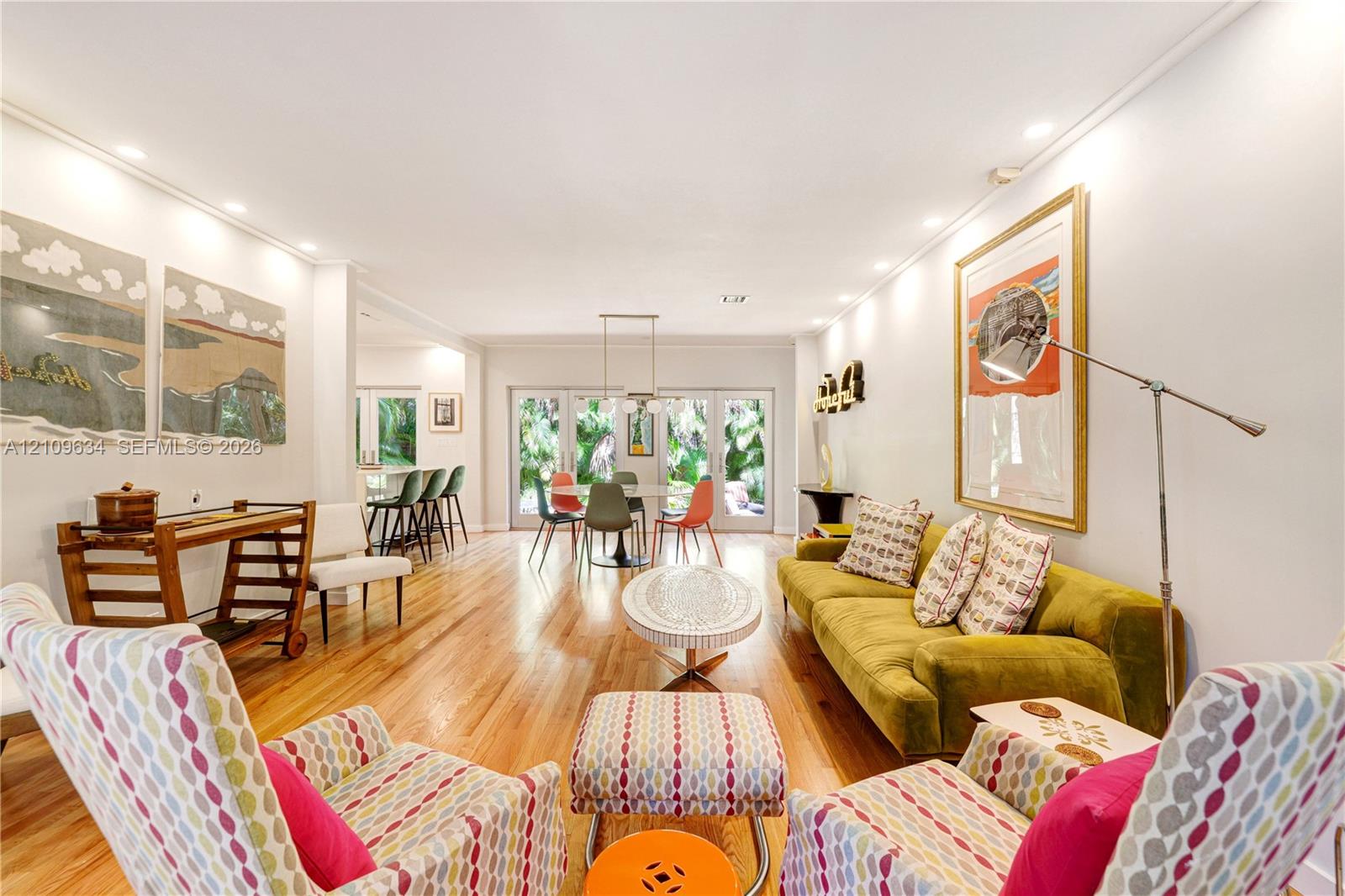 Open-concept living space featuring wood-finish flooring, recessed lighting, and expansive glass-paneled double doors