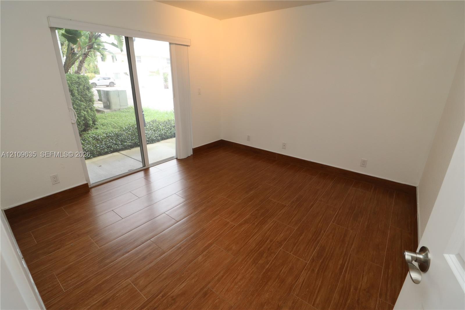 Room featuring wood-finish flooring and sliding glass doors with exterior access