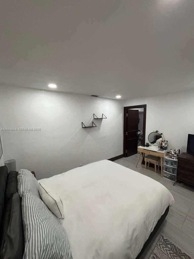 Recessed lighting, light-toned wood-finish flooring, and two wall-mounted matte black floating shelves Recessed lighting, light-toned wood-finish flooring, and two wall-mounted matte black floating shelves