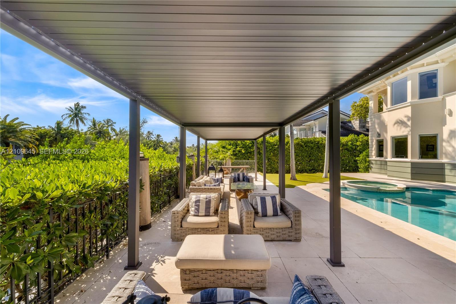 Covered outdoor patio featuring a metal pergola, large-format tile flooring, in-ground pool, and a metal perimeter fence
