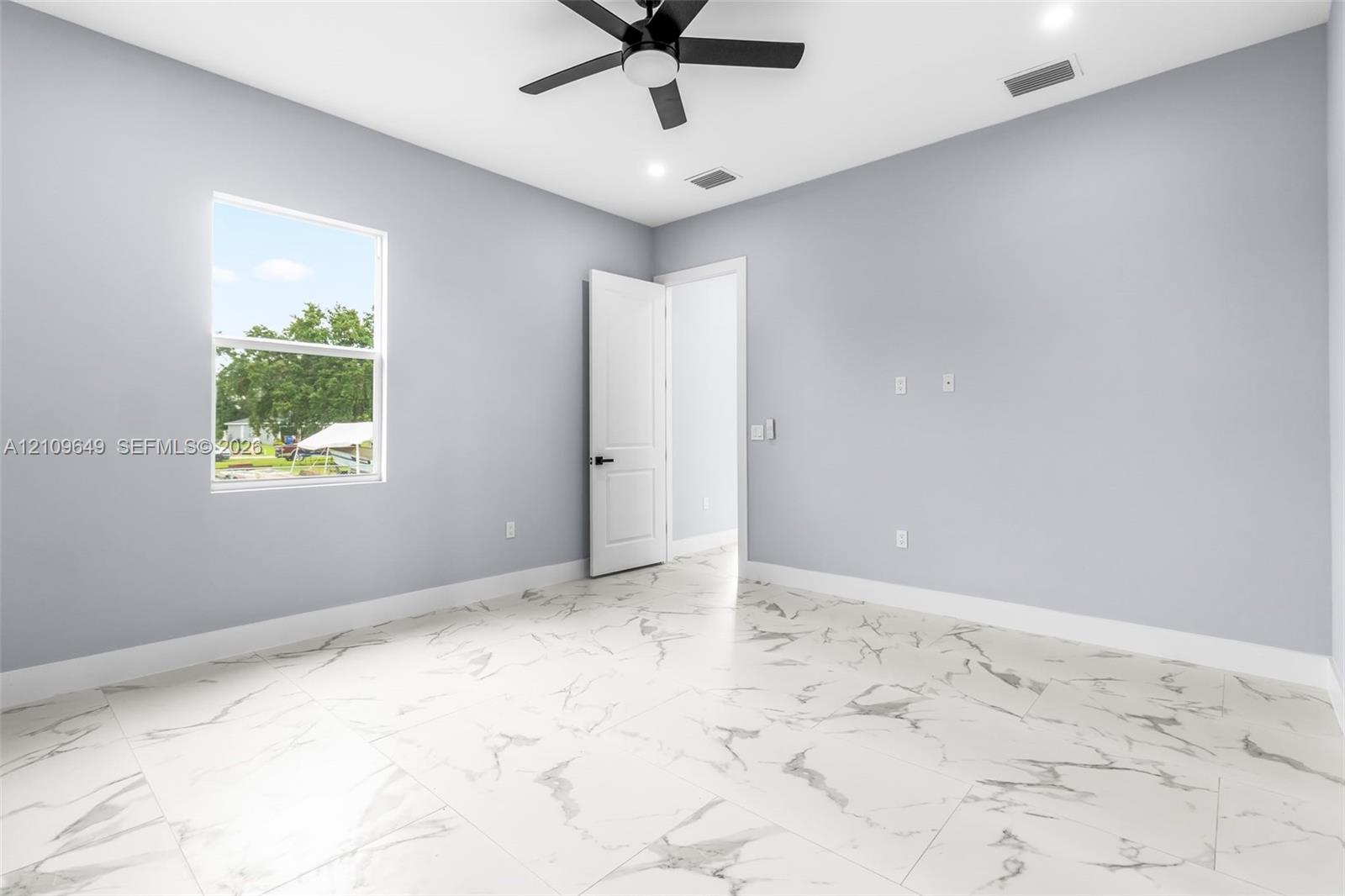 Neutral-toned room featuring large-format stone-patterned tile flooring, a multi-speed ceiling fan, recessed lighting, and a single-hung window
