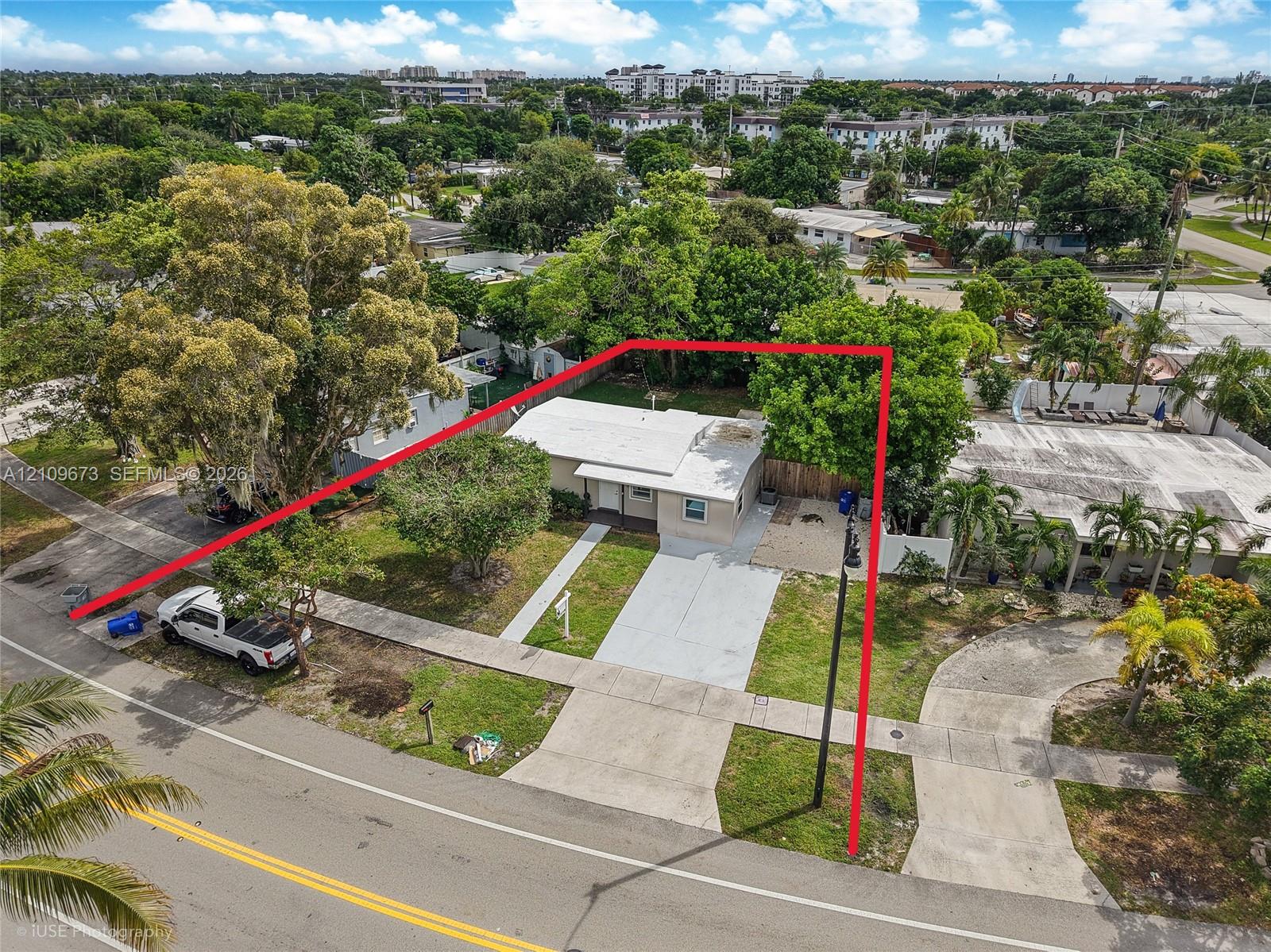 Detached residence featuring a concrete driveway, established trees, and perimeter fencing
