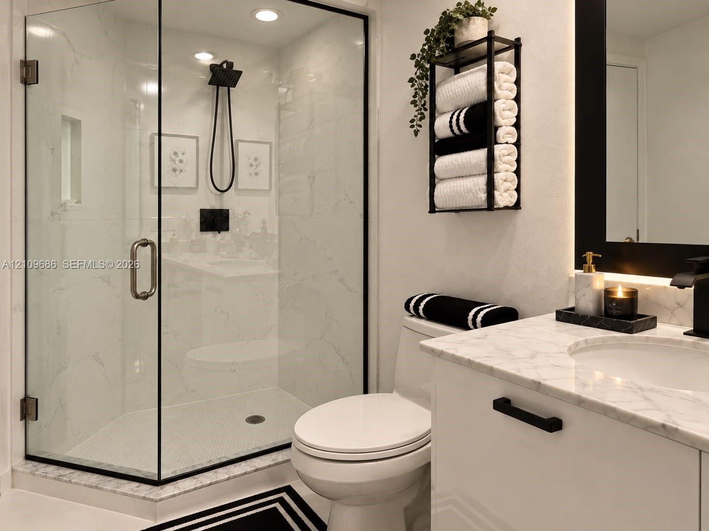 Walk-in shower with black-trimmed glass enclosure, stone-finish wall tile, and black rainfall showerhead