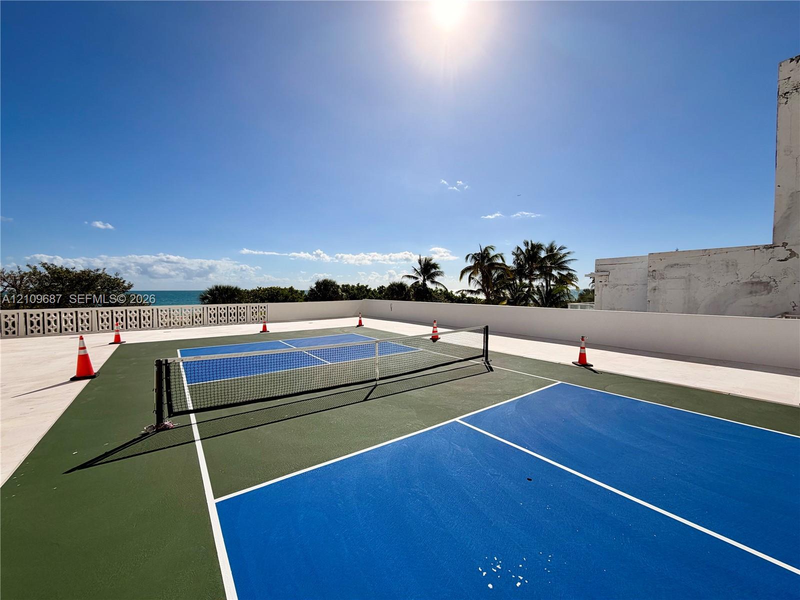 Rooftop sports court featuring a multi-color surface, net system, and decorative concrete screen wall
