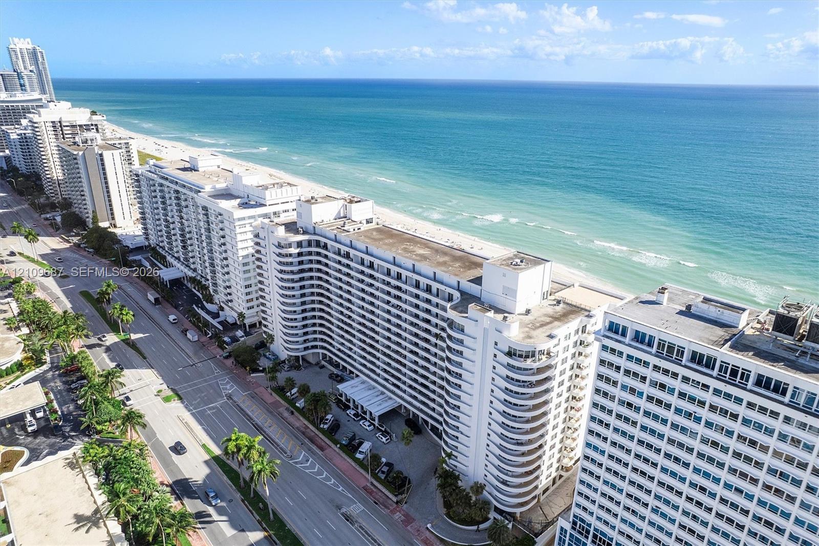 High-rise residential structure featuring multi-level balconies, expansive oceanfront positioning, and immediate proximity to the coastline