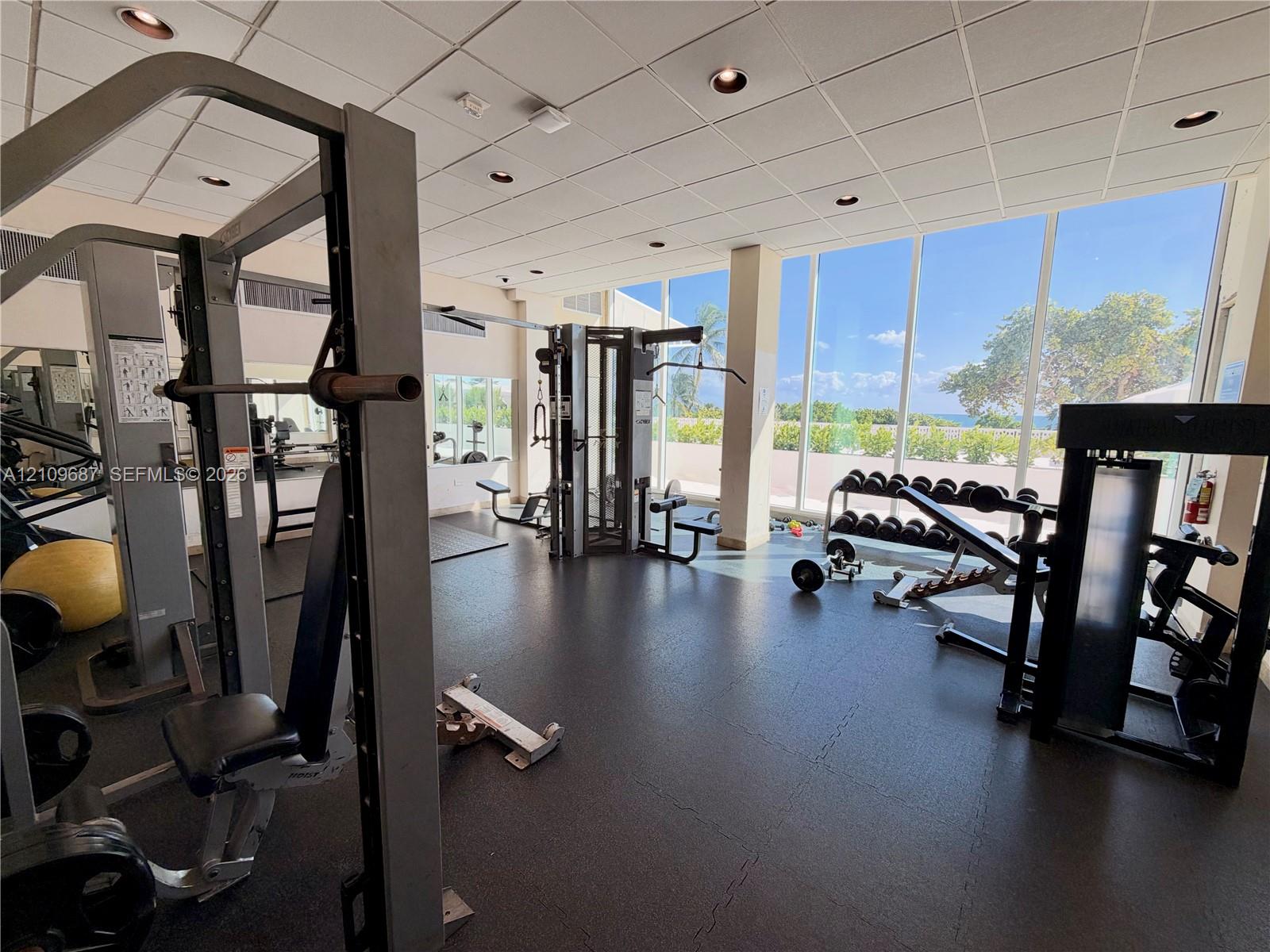 Fitness center featuring floor-to-ceiling windows, rubberized flooring, and recessed ceiling lighting