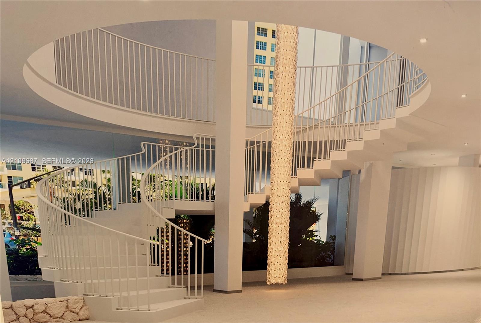 Architectural spiral staircase featuring white vertical railings, a central floor-to-ceiling light fixture, a circular mezzanine cutout, and recessed ceiling lighting