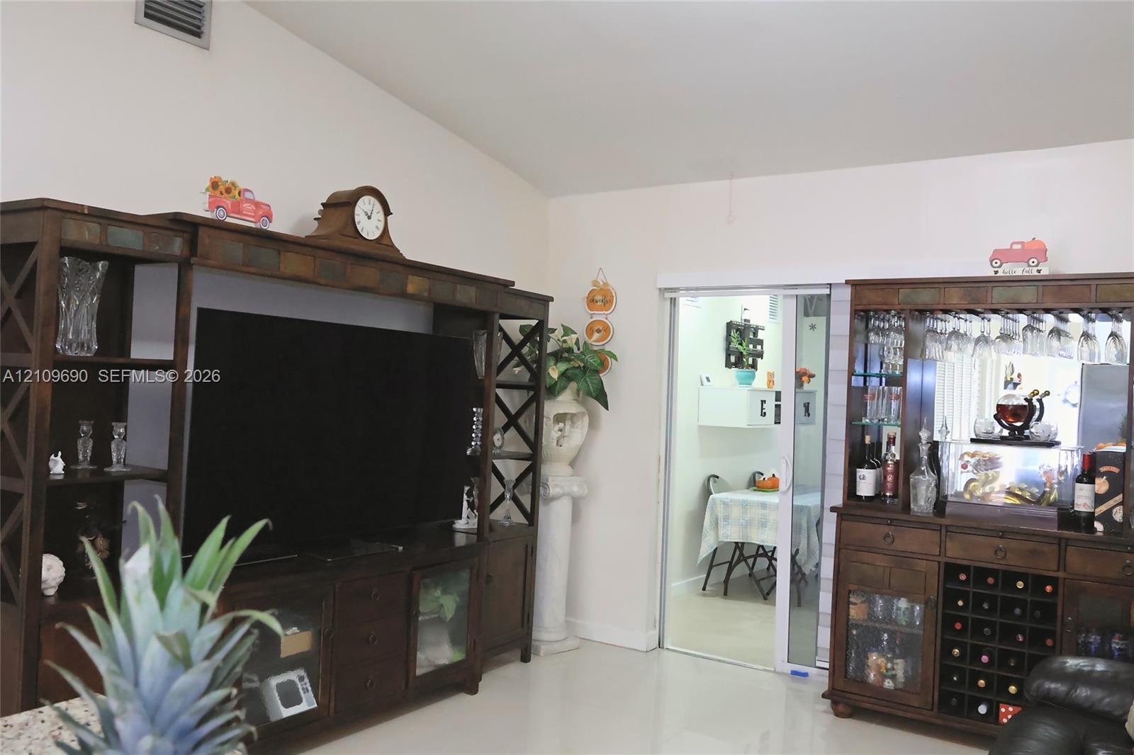 Vaulted ceiling and sliding glass door leading to a separate room