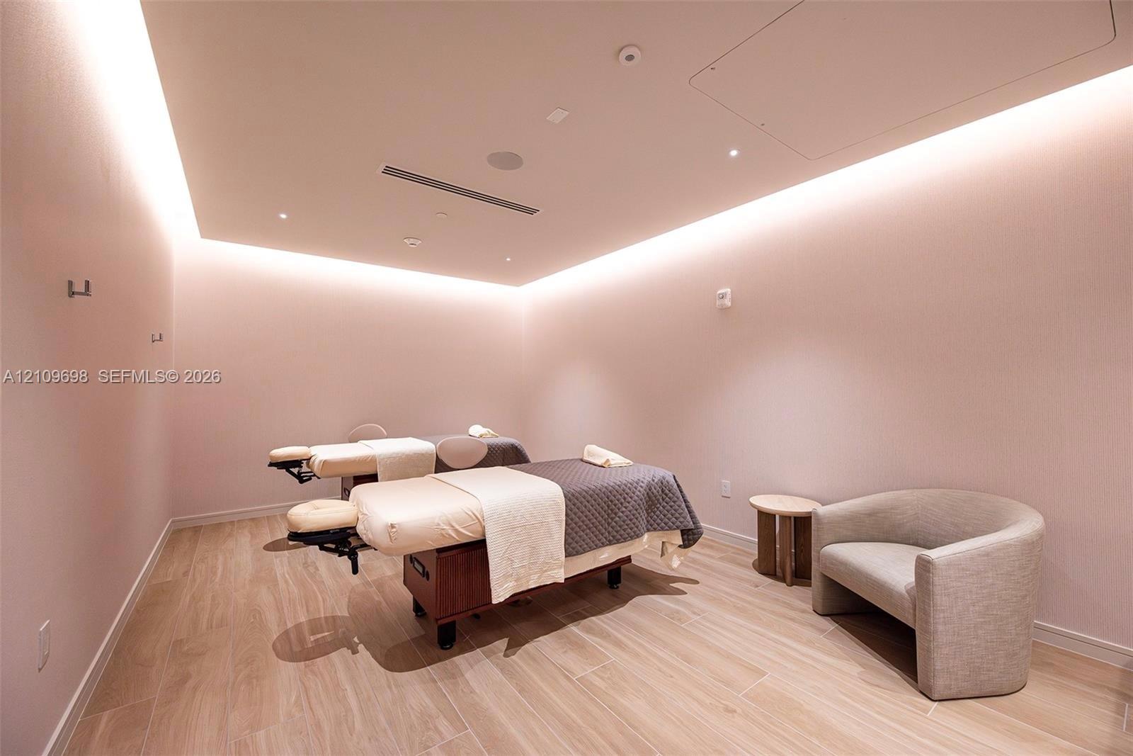 Interior room featuring wood-finish flooring, cove lighting, recessed ceiling lighting, and integrated sound system speakers