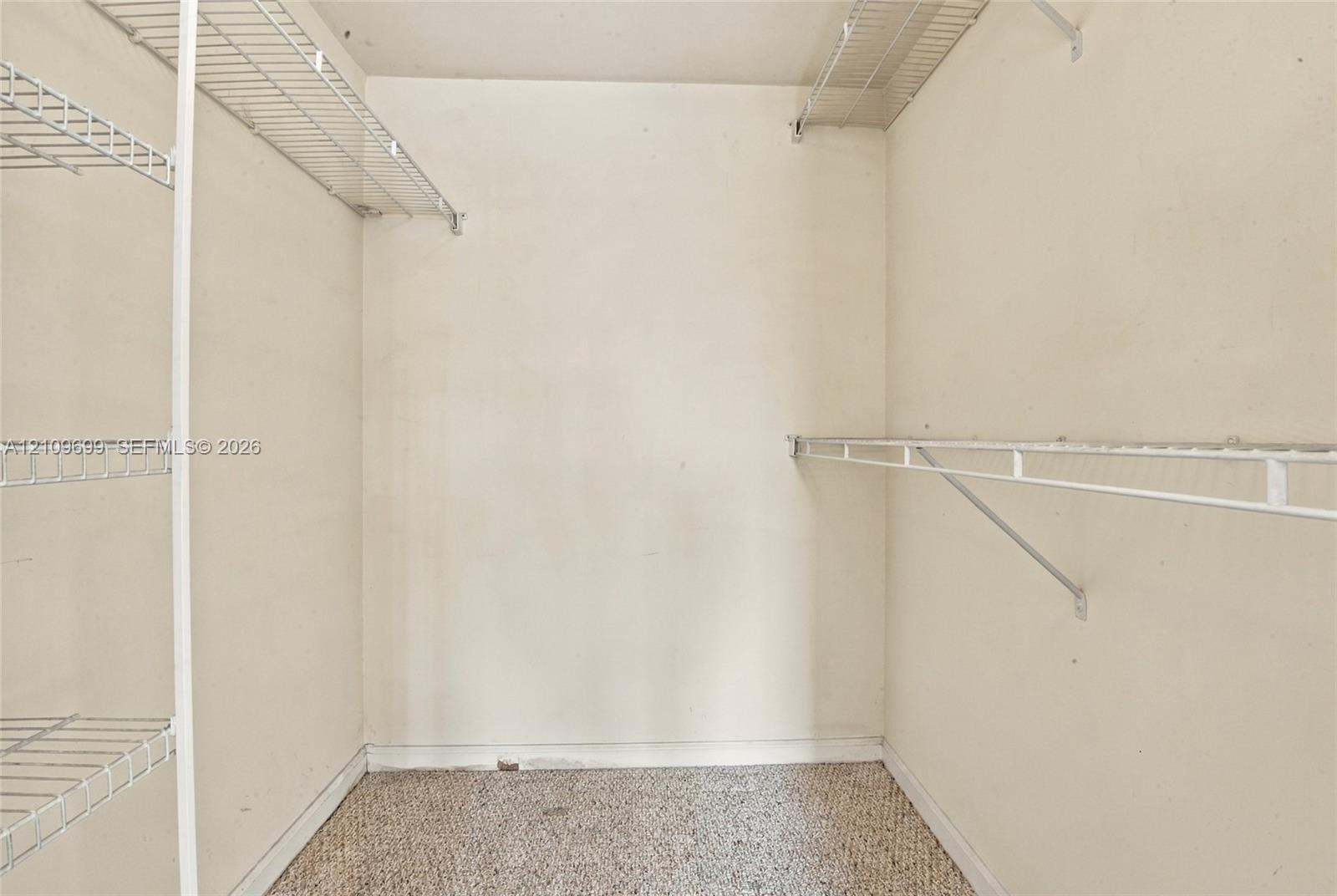 Storage space featuring white wall-mounted wire shelving units