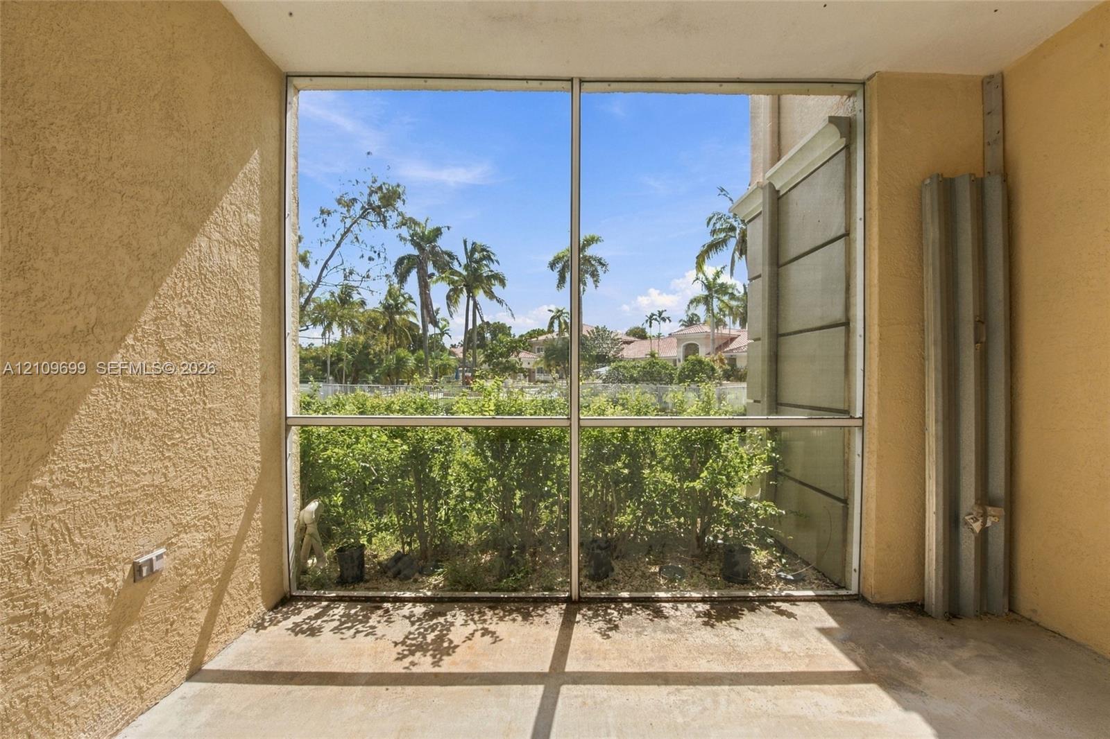 Enclosed patio featuring stucco walls, a concrete floor, floor-to-ceiling screened panels, and exterior metal hurricane shutters