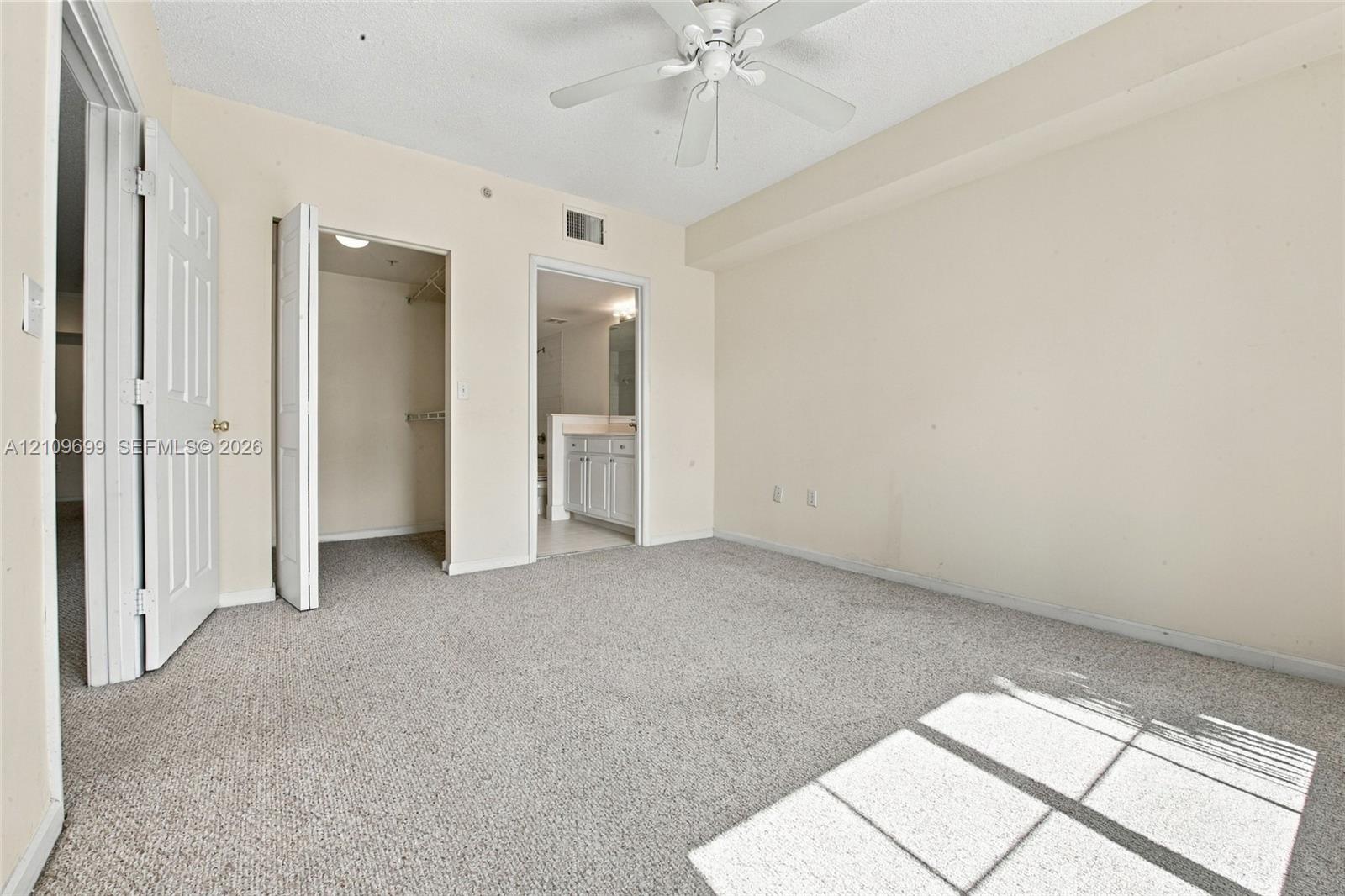 Bedroom featuring neutral carpeting, a ceiling fan with light fixture, and a built-in closet
