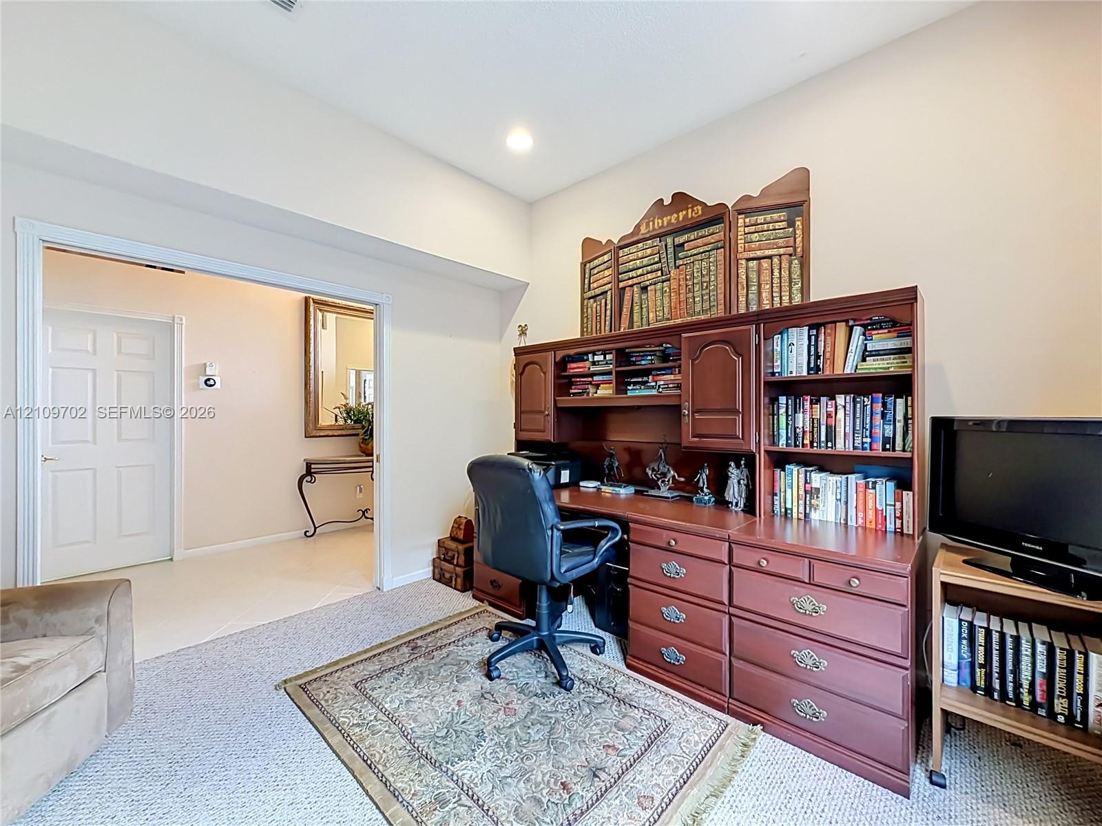 Neutral-toned interior space featuring recessed lighting, a multi-panel door, and wall-to-wall carpeting
