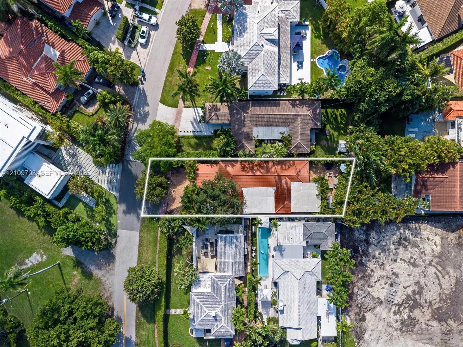 Aerial perspective of property featuring a tile roof, mature landscape, and hardscaped patio areas