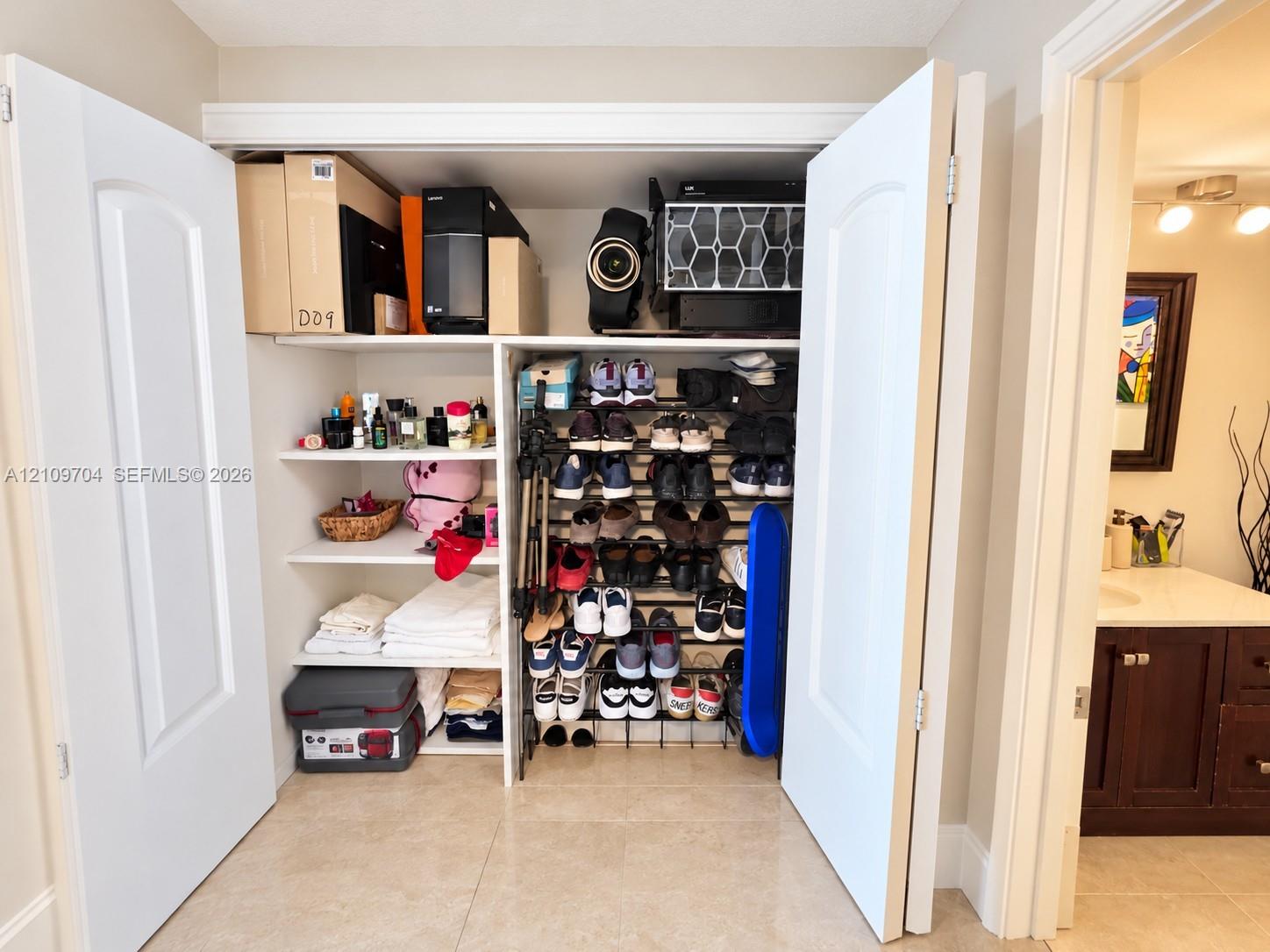 Closet featuring white paneled double doors and integrated white shelving