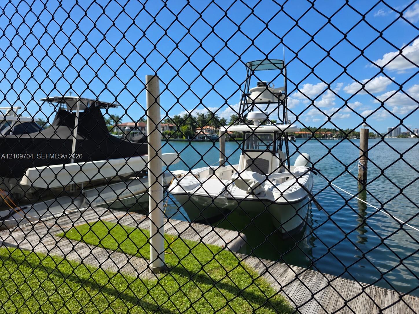 Waterfront property featuring a wooden bulkhead, piling moorings, and direct access to an expansive canal