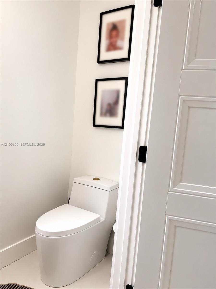 One-piece dual-flush toilet, solid-core three-panel interior door, and matte black door hardware