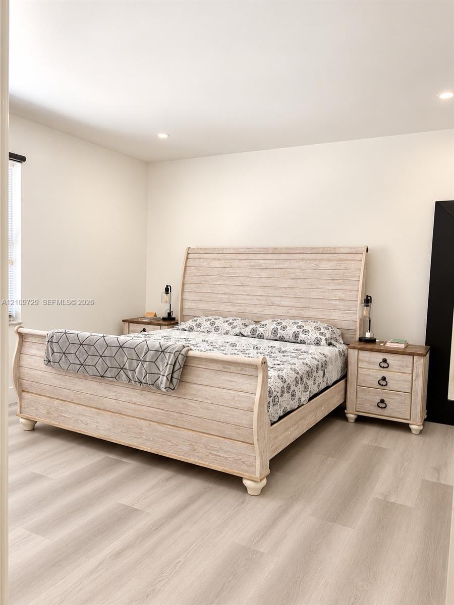 Neutral walls, recessed ceiling lighting, and wood-finish flooring
