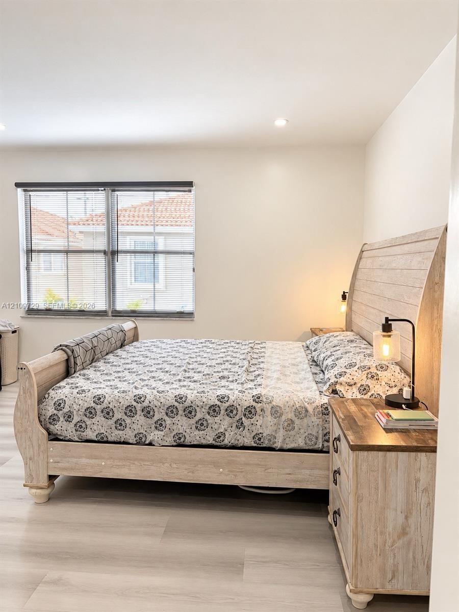 Neutral-toned walls, wood-finish flooring, and recessed ceiling lighting
