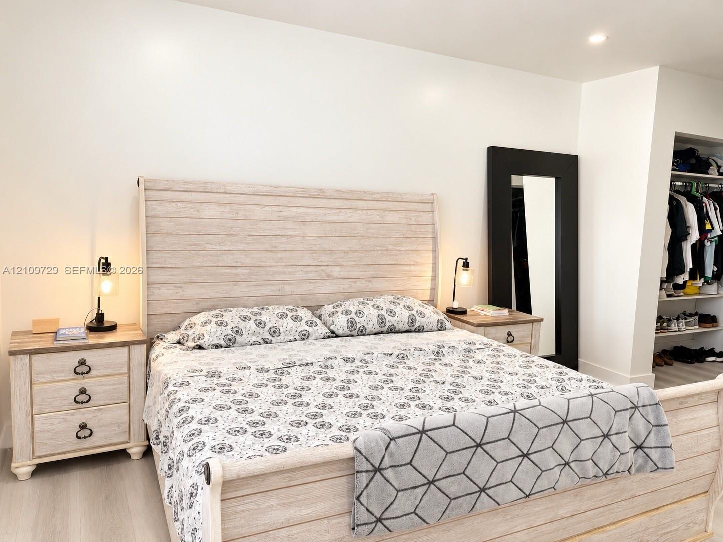 Recessed lighting, wood-finish flooring, and a reach-in closet with built-in shelving