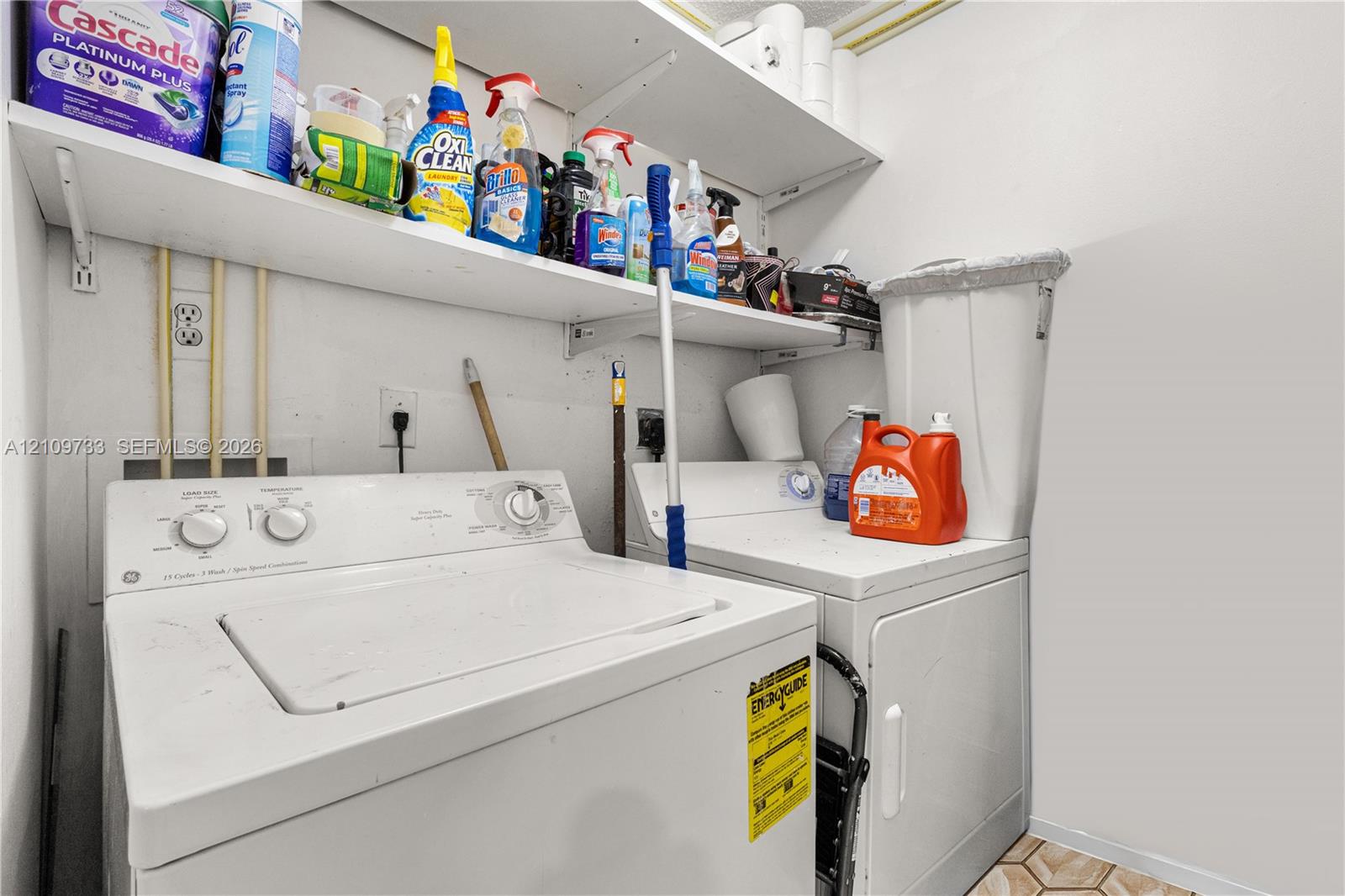 Laundry space featuring built-in white shelving and tile flooring Laundry space featuring built-in white shelving and tile flooring