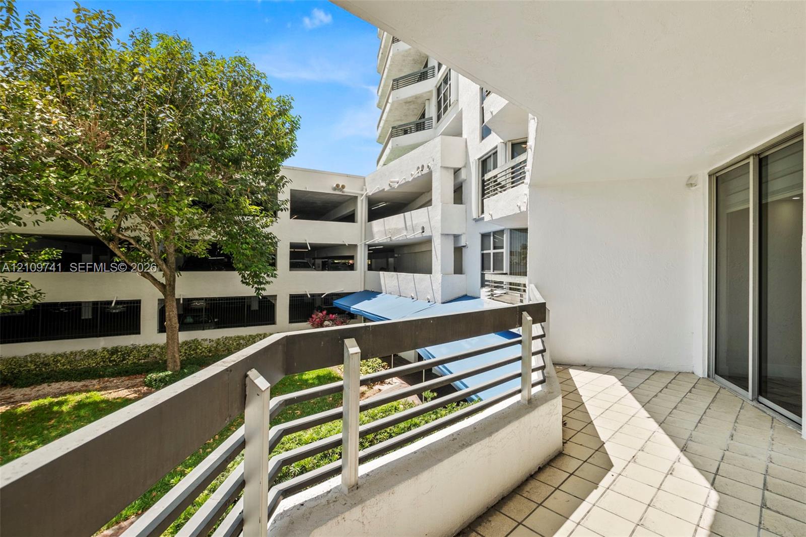 Covered balcony featuring tile flooring and a horizontal metal railing