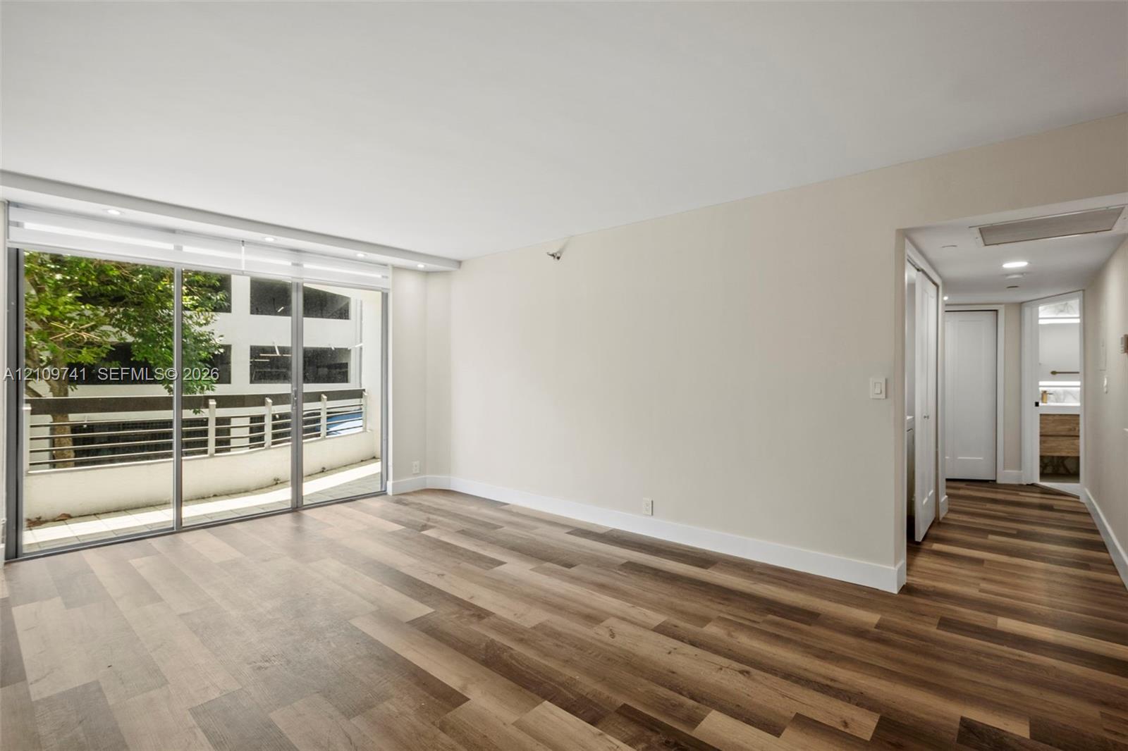 Wood-finish flooring, full-height sliding glass doors, and recessed ceiling lighting Wood-finish flooring, full-height sliding glass doors, and recessed ceiling lighting