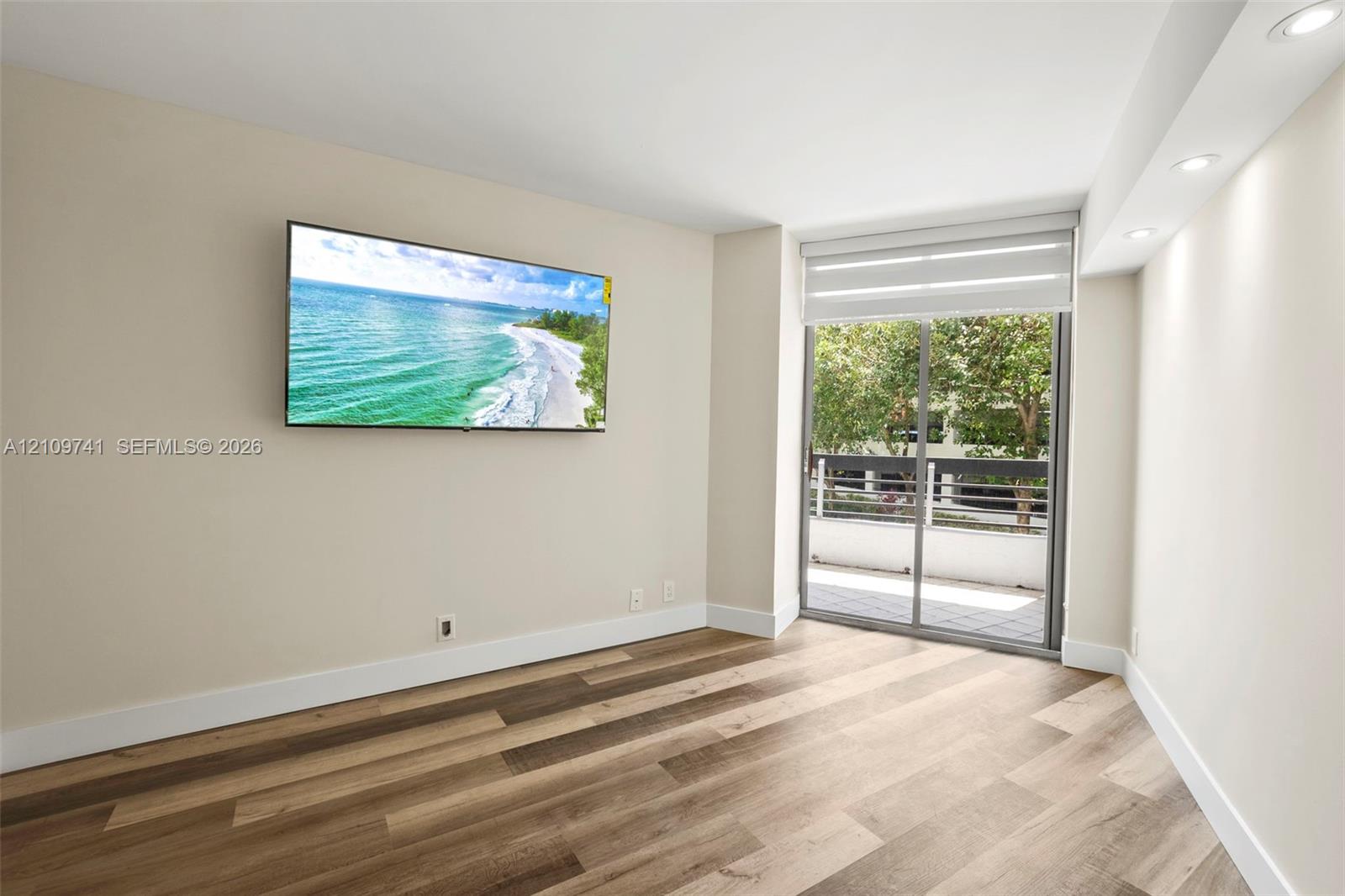 Interior space featuring wood-finish flooring, recessed lighting, and a sliding glass door providing external access