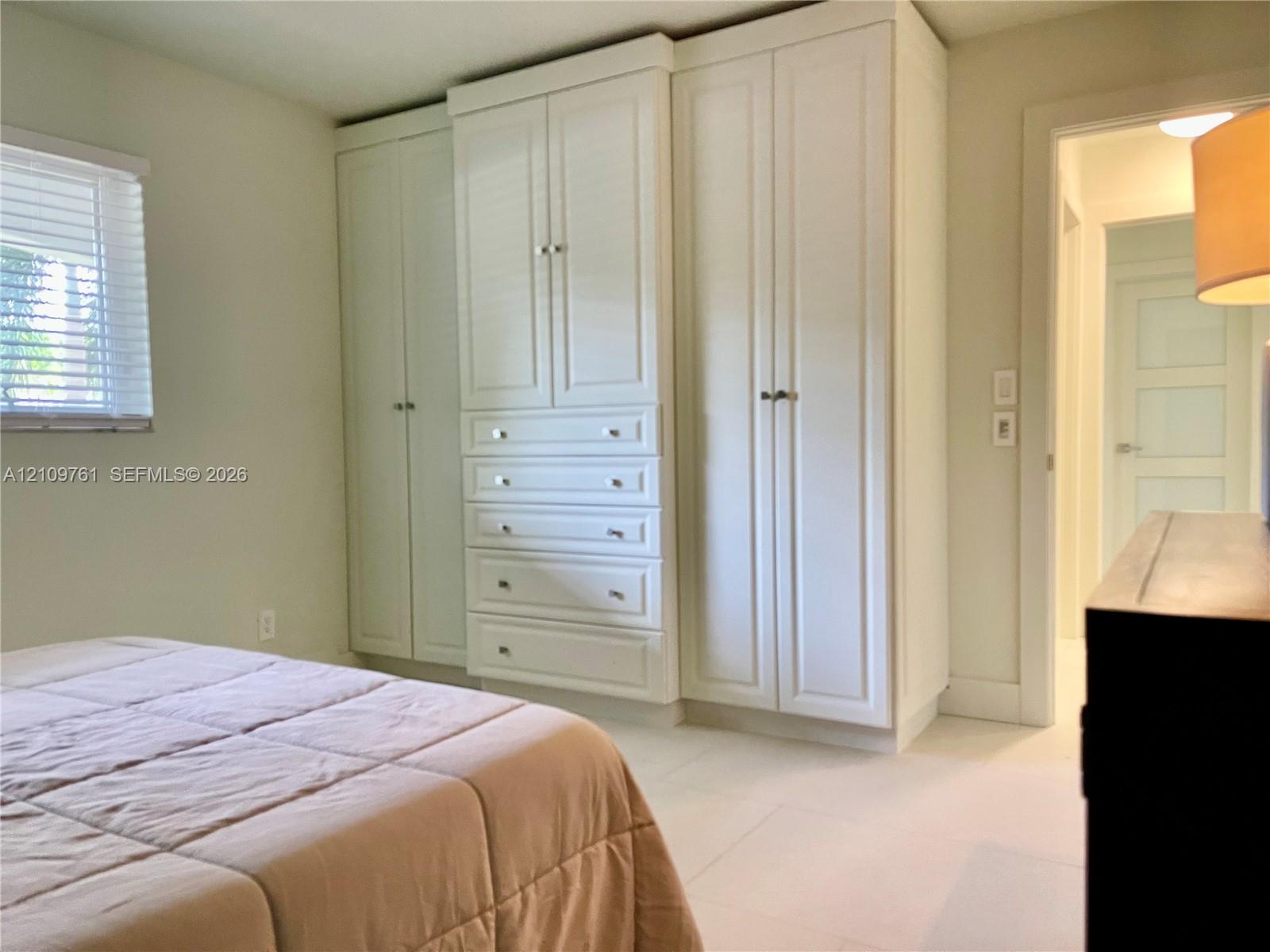 Custom built-in white cabinetry featuring shaker-style doors, integrated storage drawers, and brushed metal hardware