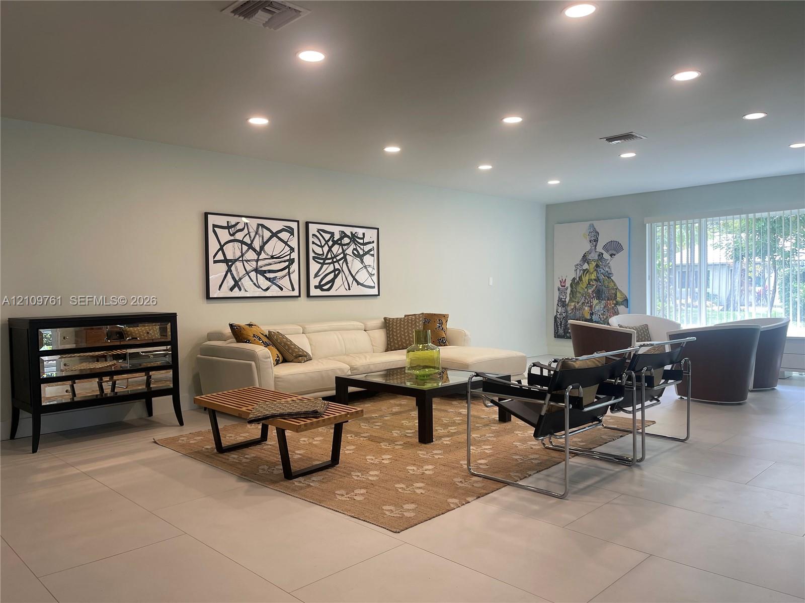 Neutral-toned ceramic tile flooring, recessed ceiling lighting, and vertical window blinds Neutral-toned ceramic tile flooring, recessed ceiling lighting, and vertical window blinds