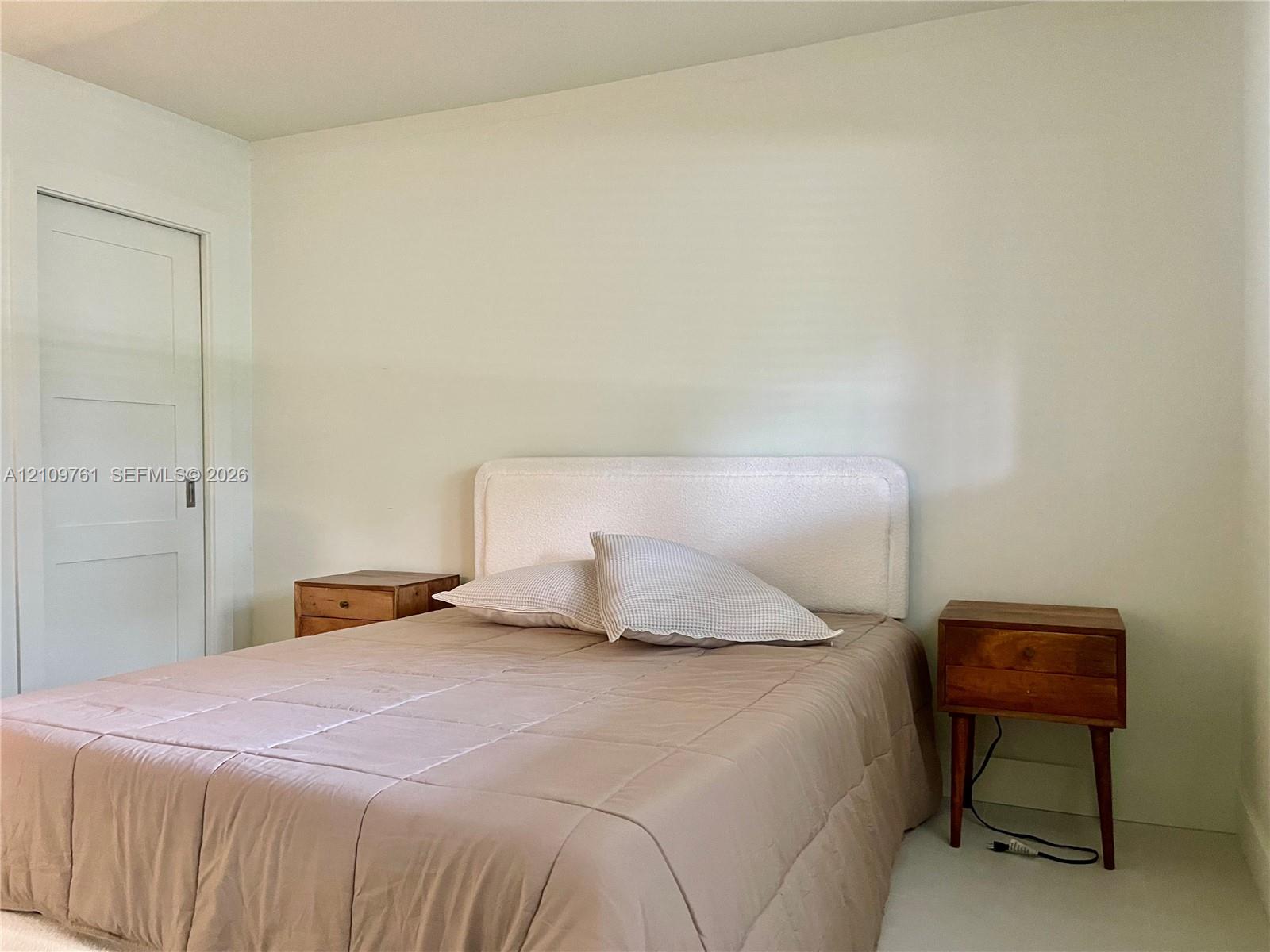Neutral interior space featuring smooth wall surfaces, a single-panel interior door, and clean finishes