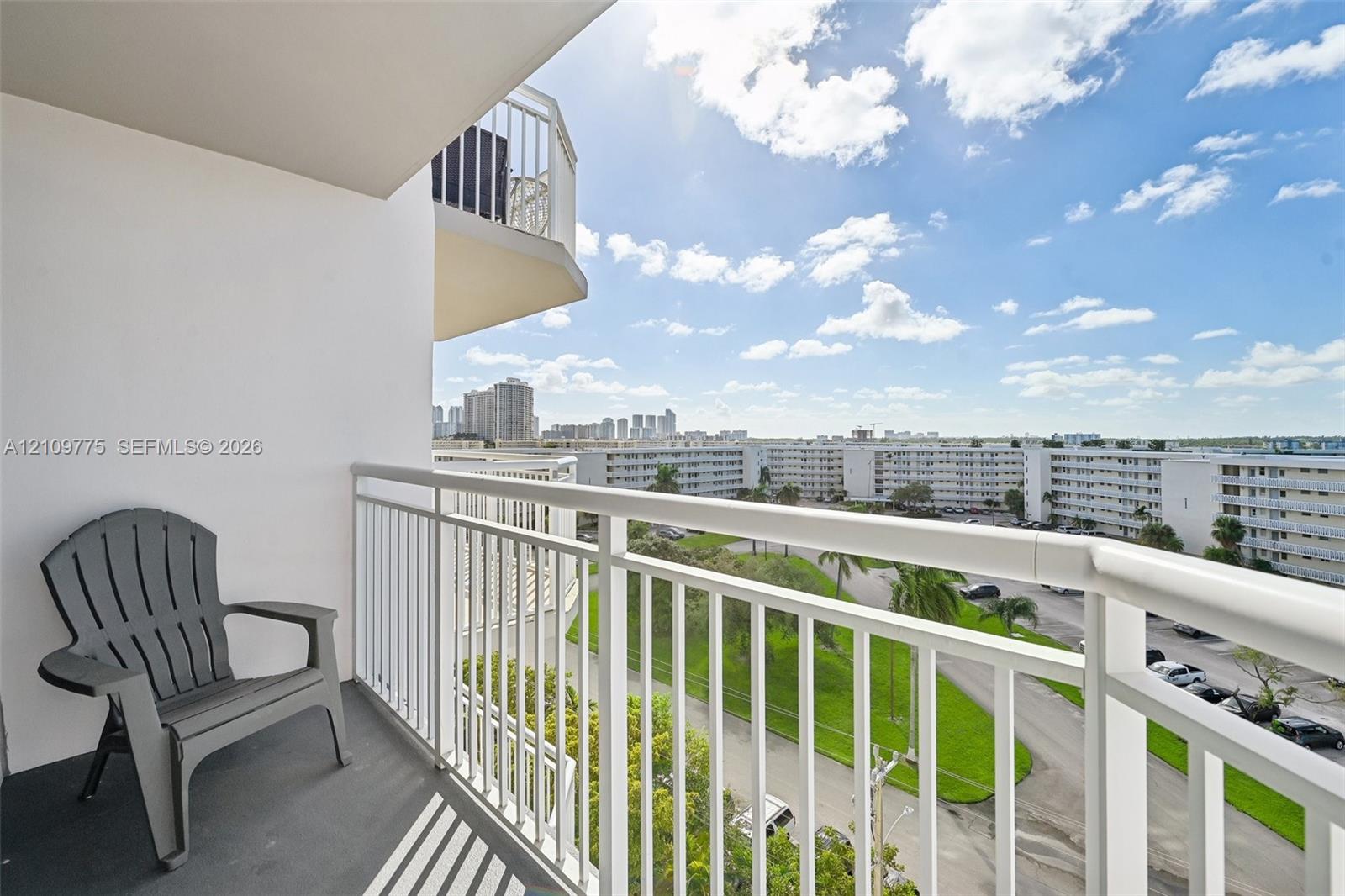 Private balcony featuring vertical metal railings and concrete flooring, overlooking an urban landscape
