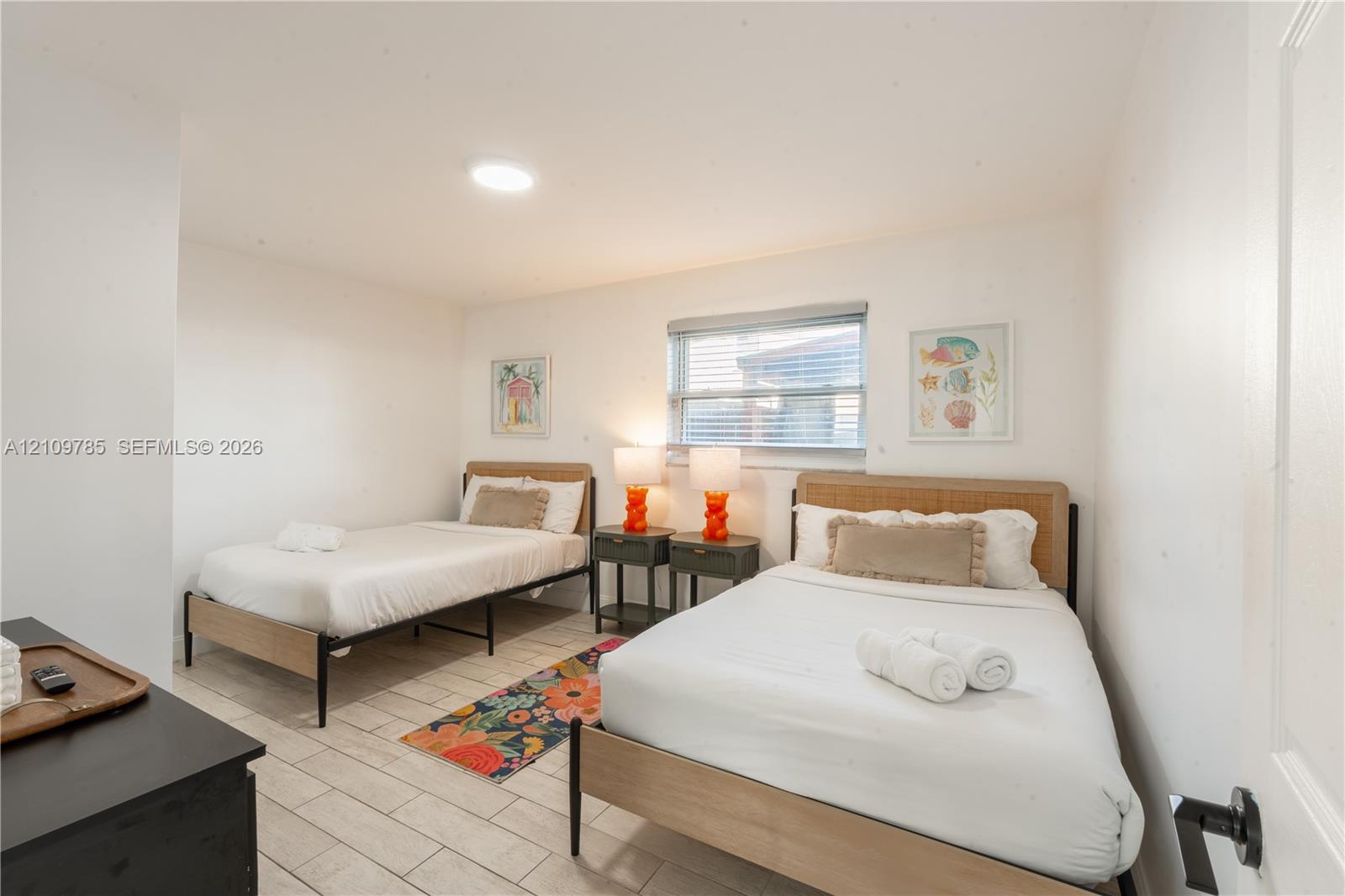 Neutral-toned ceramic tile flooring, flush-mount lighting fixture, and horizontal blind window treatment