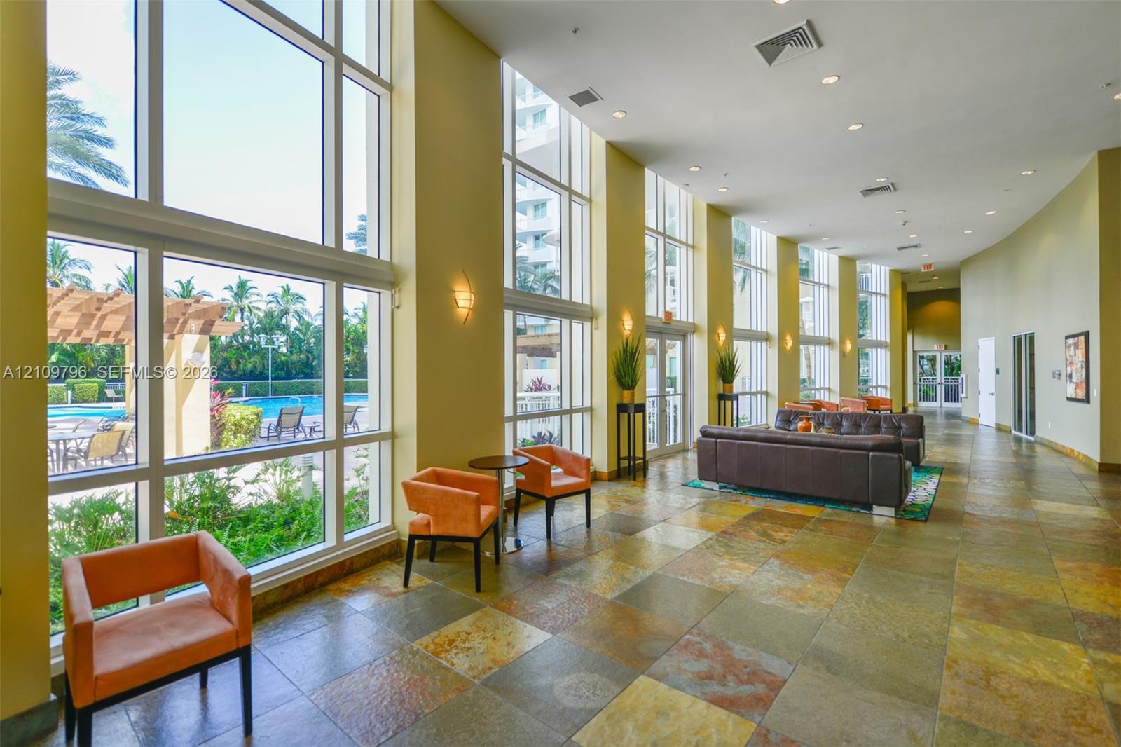 Floor-to-ceiling windows featuring expansive natural lighting, stone-tiled flooring, and recessed ceiling lighting